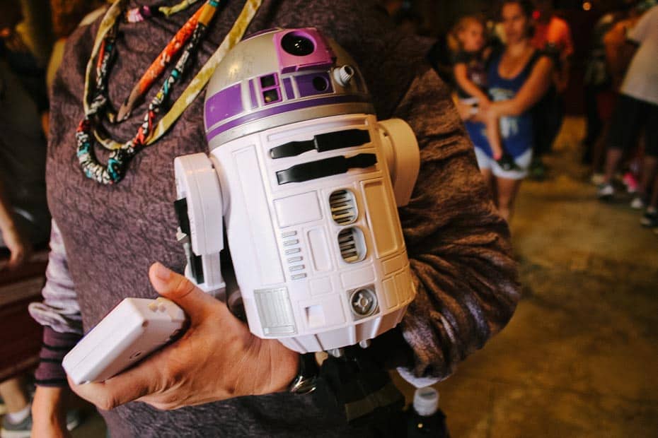 a cast member holding a sample droid 