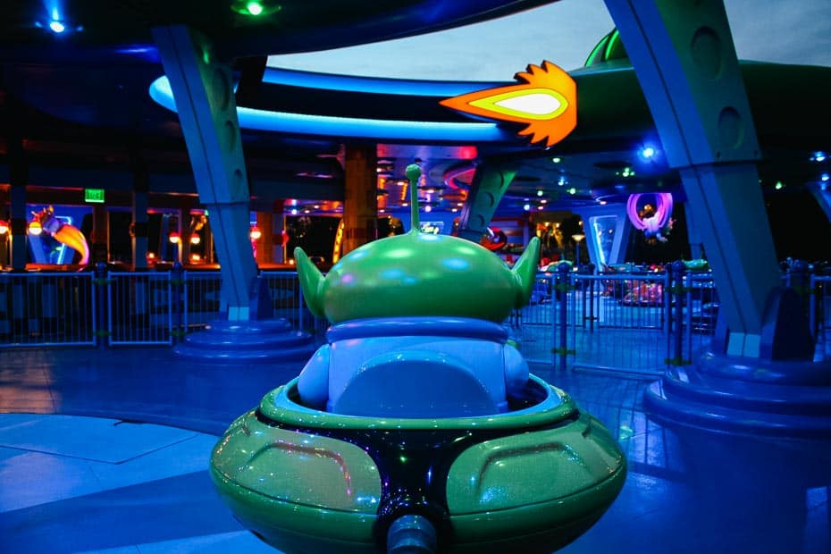 an alien in front of the ride vehicle on Alien's Swirling Saucers