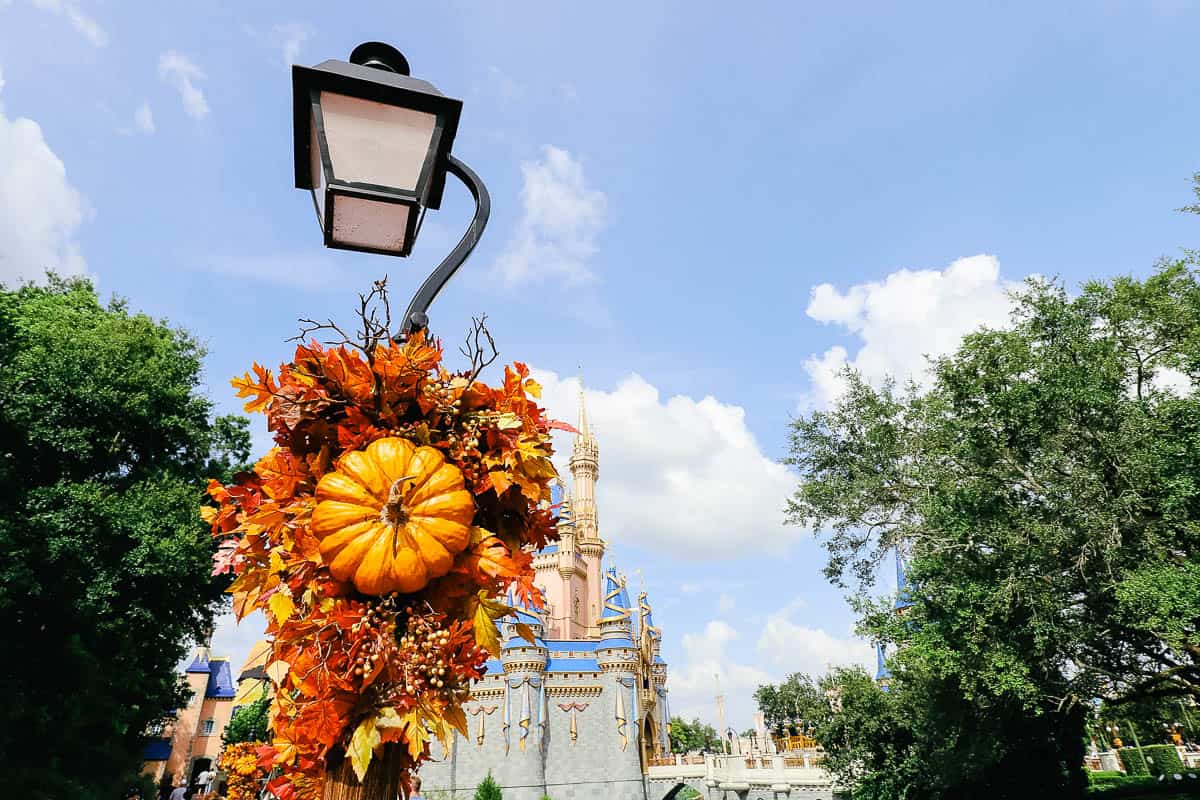 a small pumpkin with decor wrapped around a light pole 