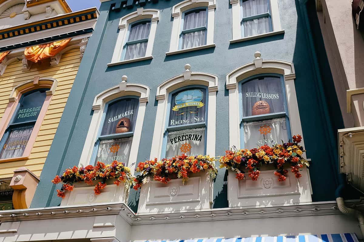 the windows on Main Street at Magic Kingdom have jack o lanterns displayed 