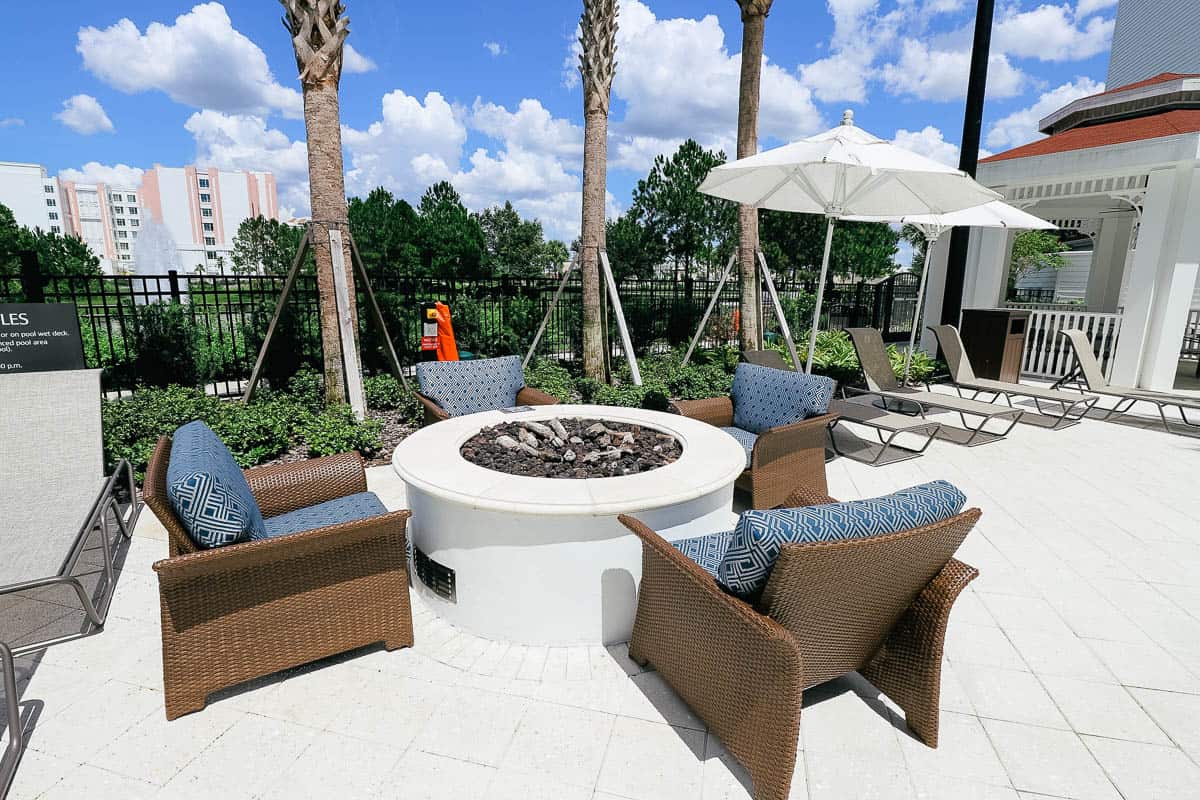 a grouping of chairs around a firepit at the pool at Residence Inn near Disney World 