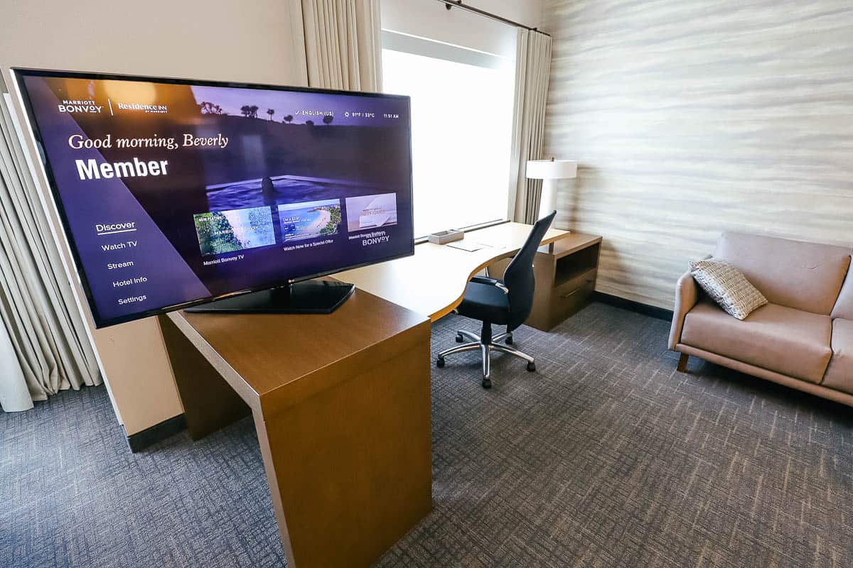 a desk and a TV on a swivel that faces the living room and bedroom 