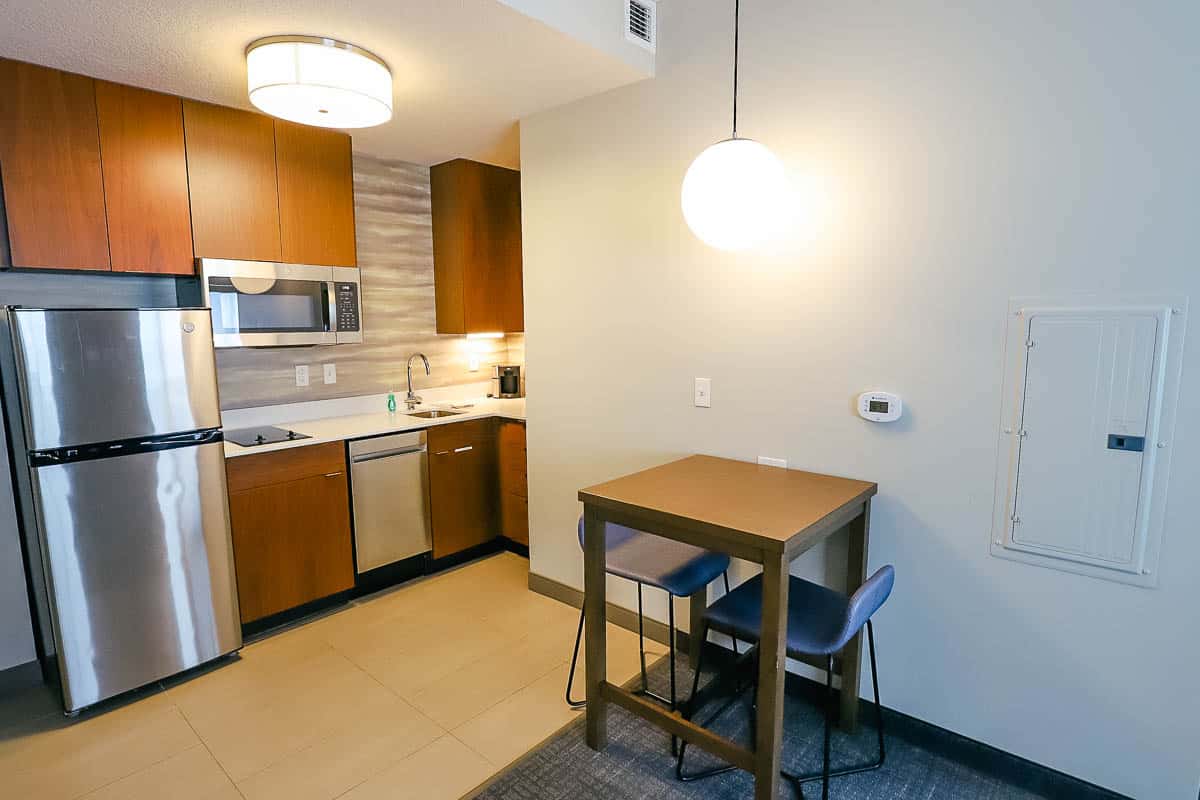 a counter height table for two with a light fixture over it 