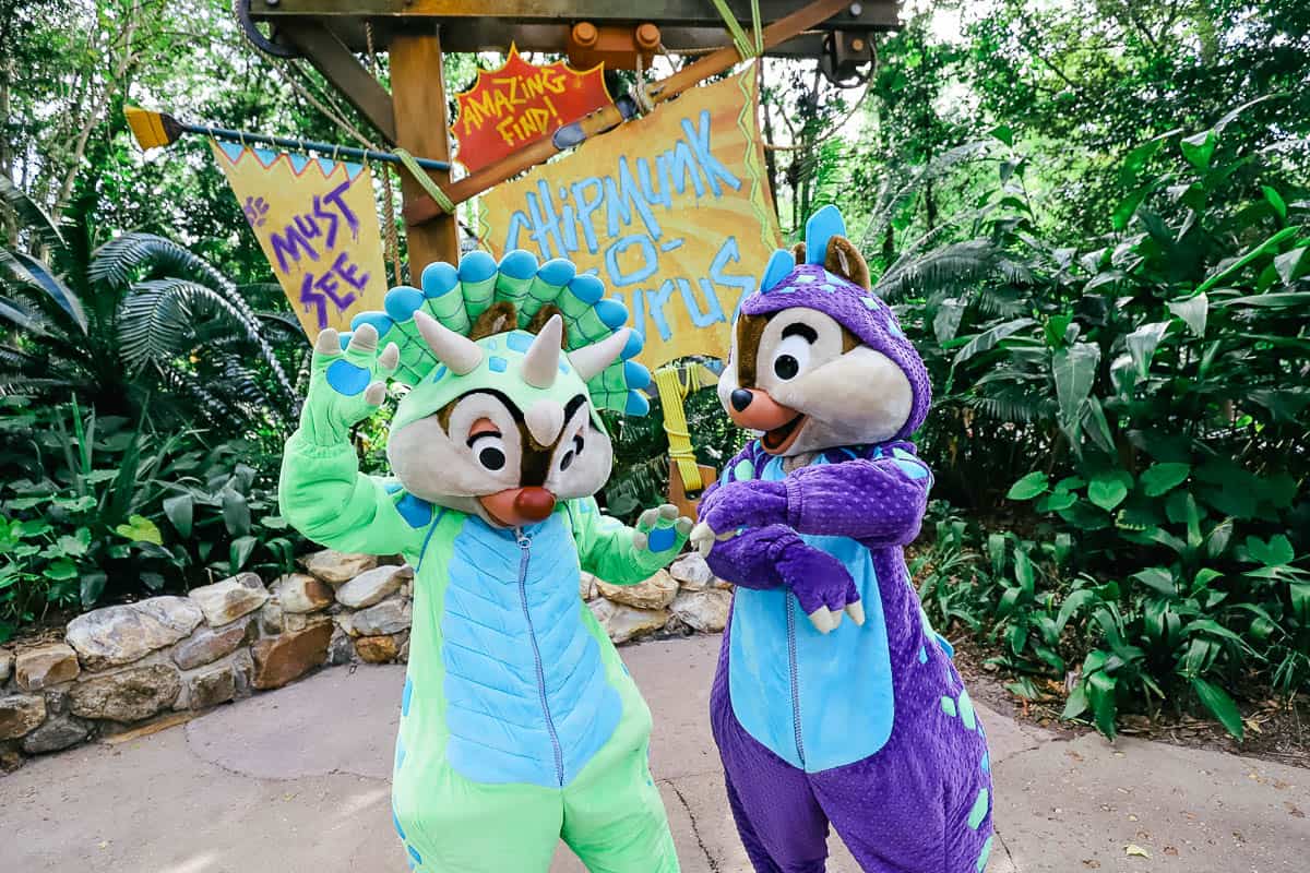 Dale wears a green dinosaur costume and Chip wears a purple costume. 