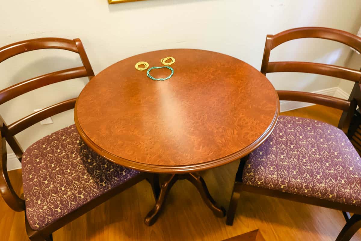 a pair of Mardi Gras beads shaped like a hidden Mickey on the table 