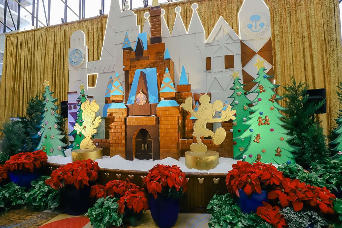 photo with golden statues of Mickey and Minnie Mouse in front of the gingerbread display 