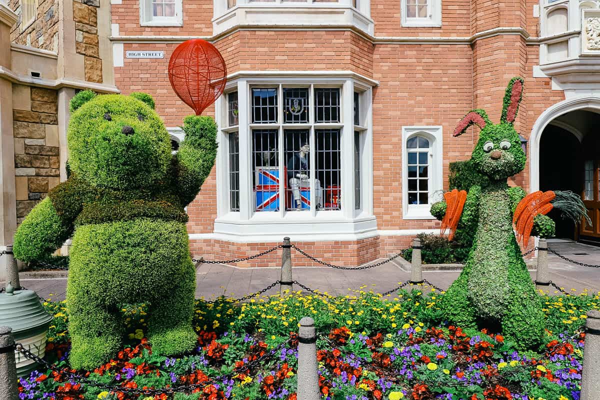 Winnie the Pooh with a red balloon and Rabbit with orange carrots in topiary form. 