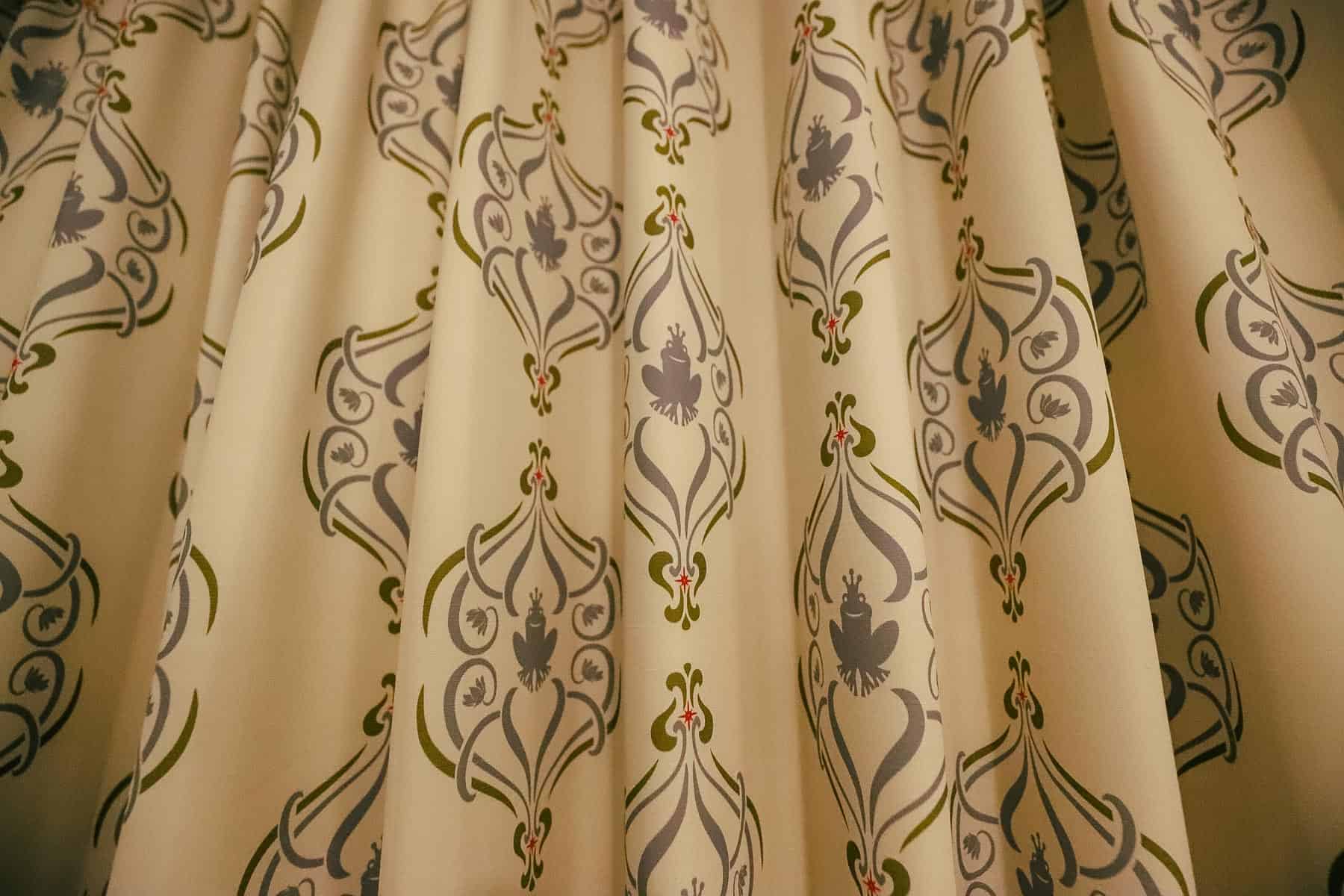 the room curtains have frogs with tiaras 