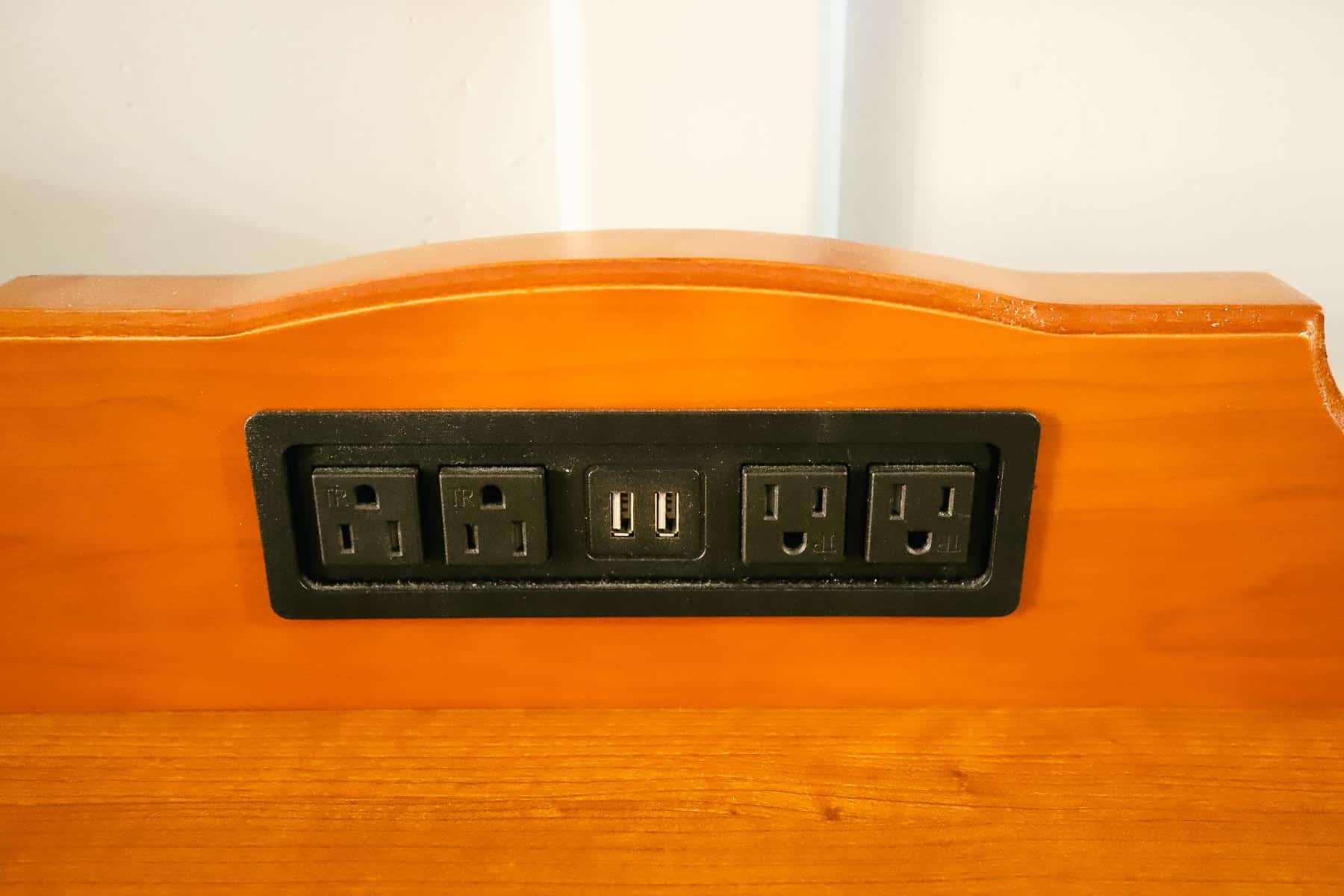 a strip of outlets and USB ports in the dresser