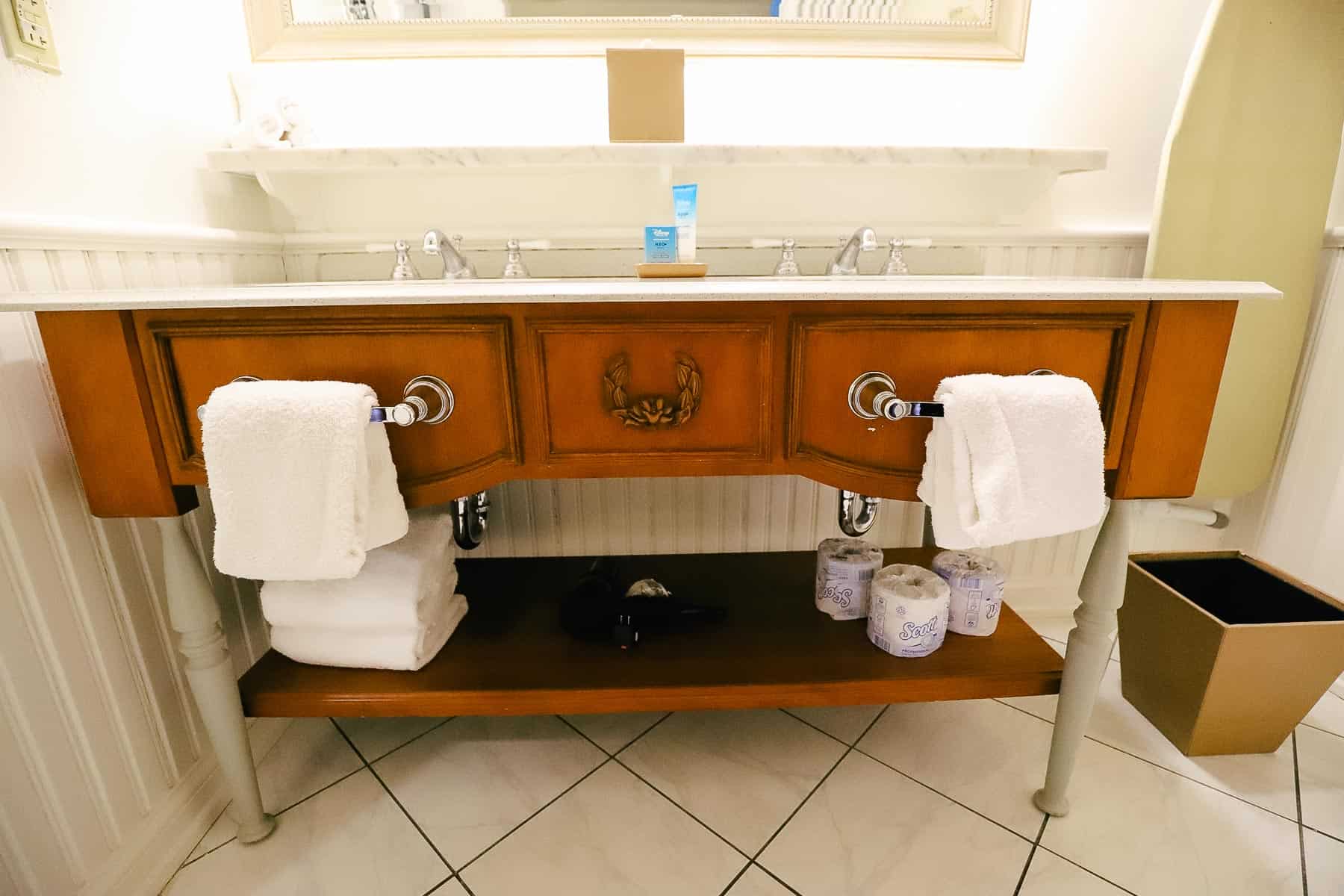the vanity with an open shelf to store items underneath 