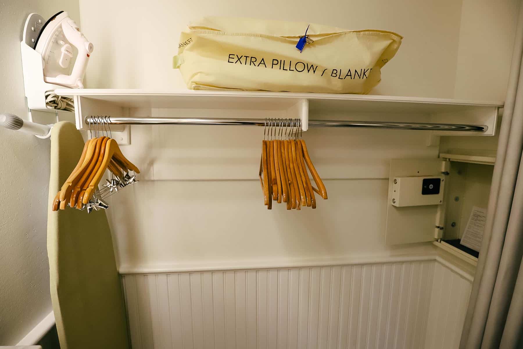 an open closet area with an iron, an ironing board, and an in-room safe 