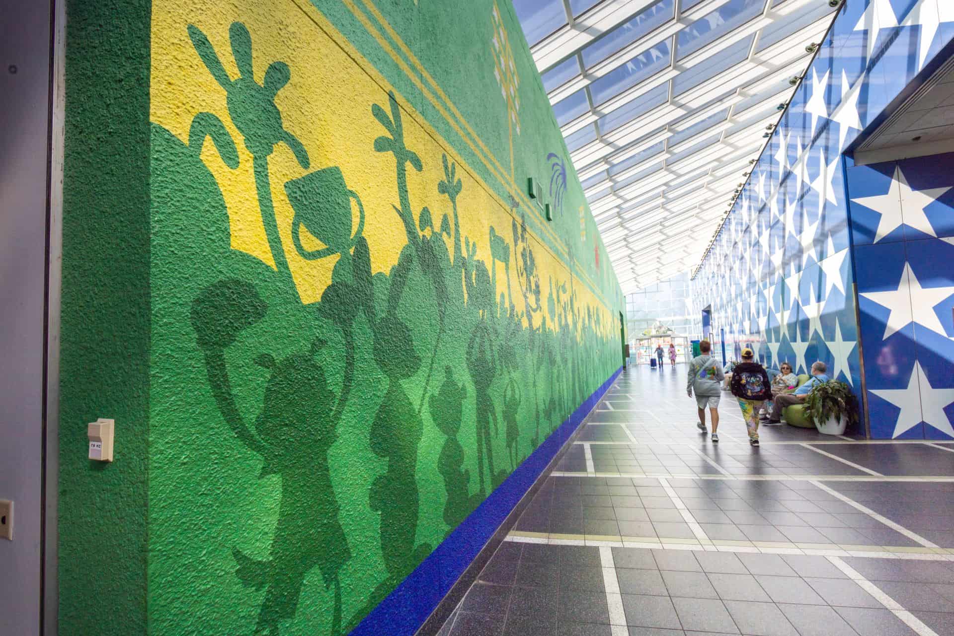 a mural featuring character silhouettes playing various sports in green and yellow 