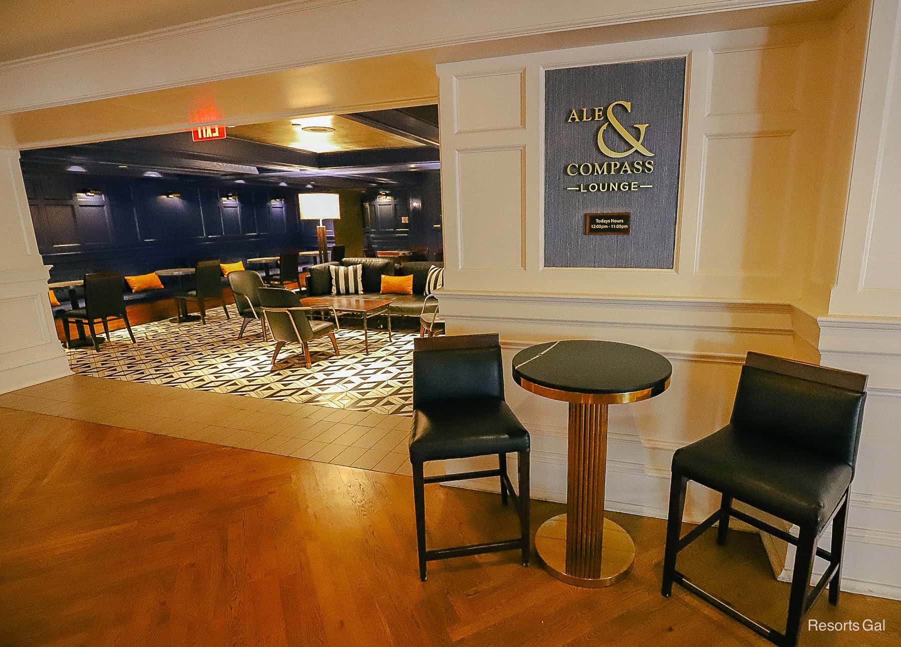 a table with two bar stools sitting outside the lobby entrance of the lounge 