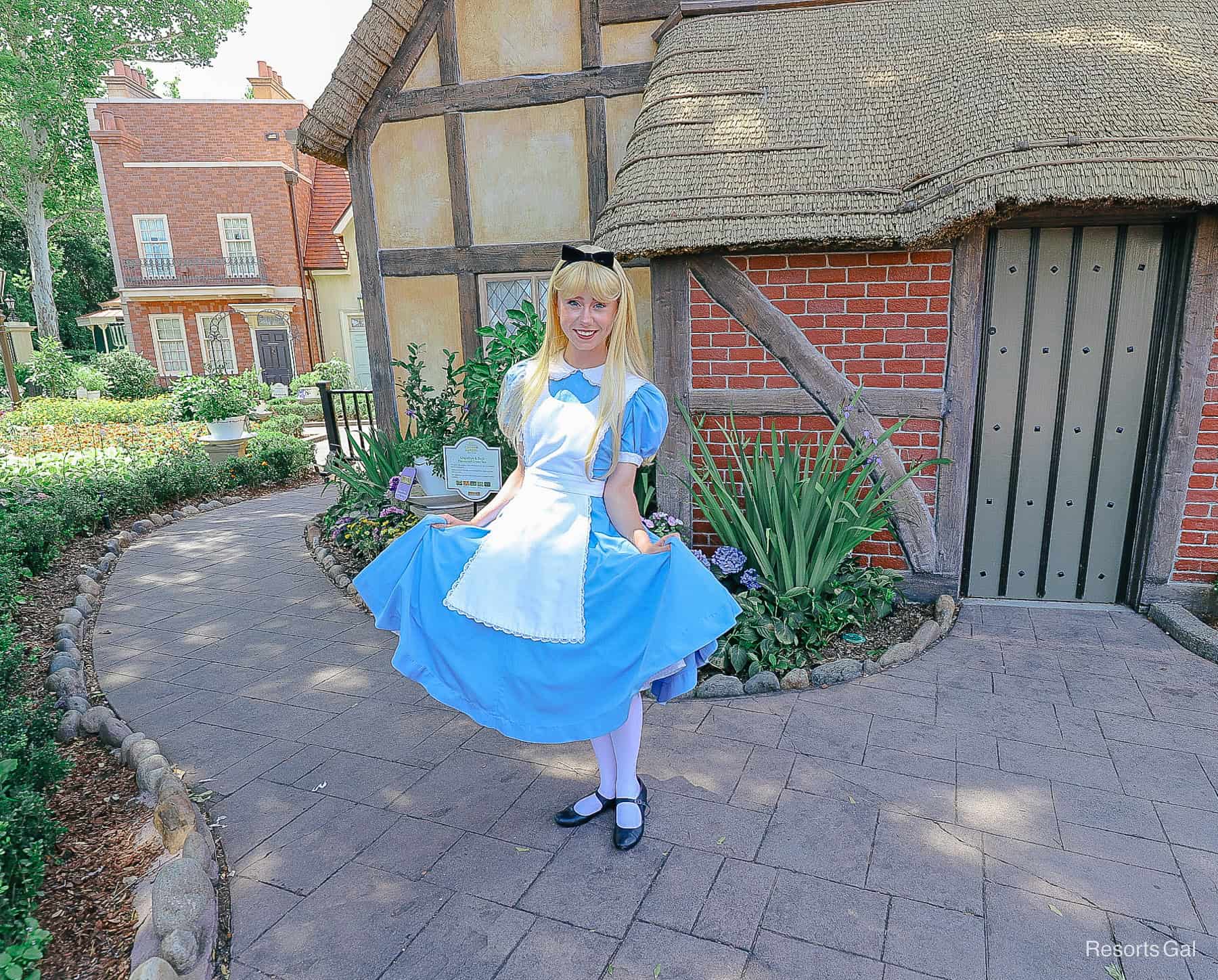 Alices poses in her blue dress with white pinafore at the United Kingdom Pavilion in Epcot 