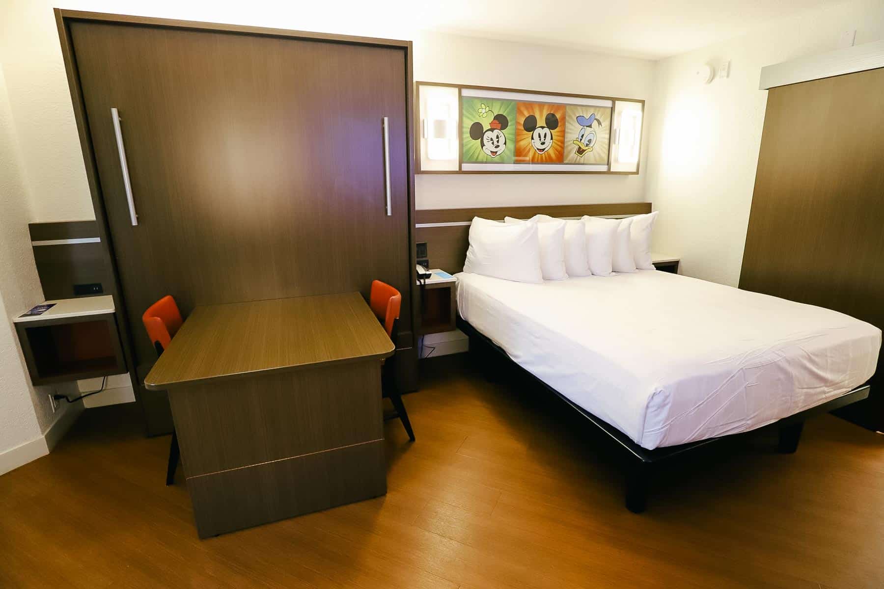 a guest room with a table bed and queen size bed at All-Star Music Resort 