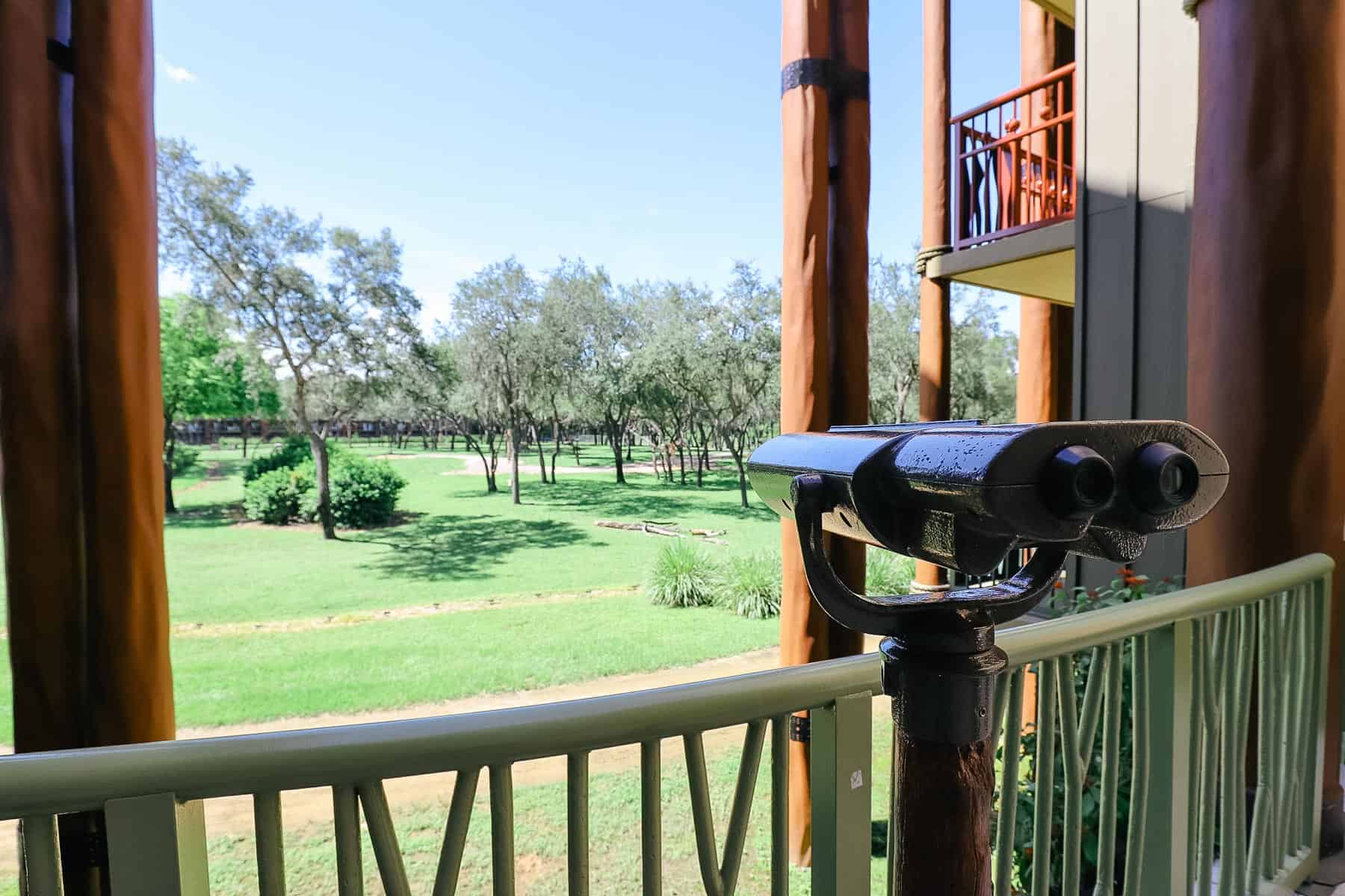 a pair of binoculars to view the animals with a giraffe in the distance 