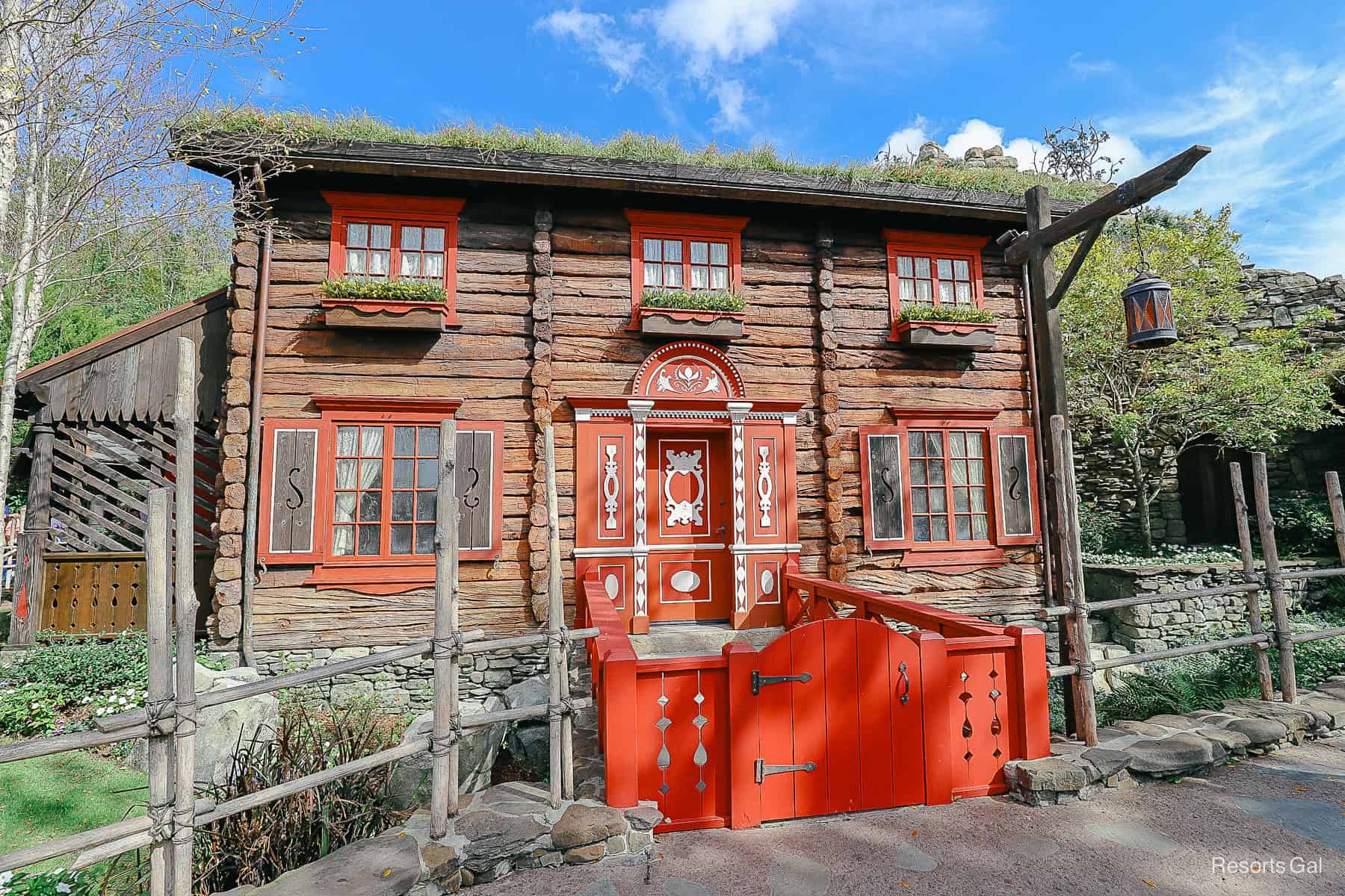 the Royal Sommerhus brown summer home with red trim and grass roof at Epcot 