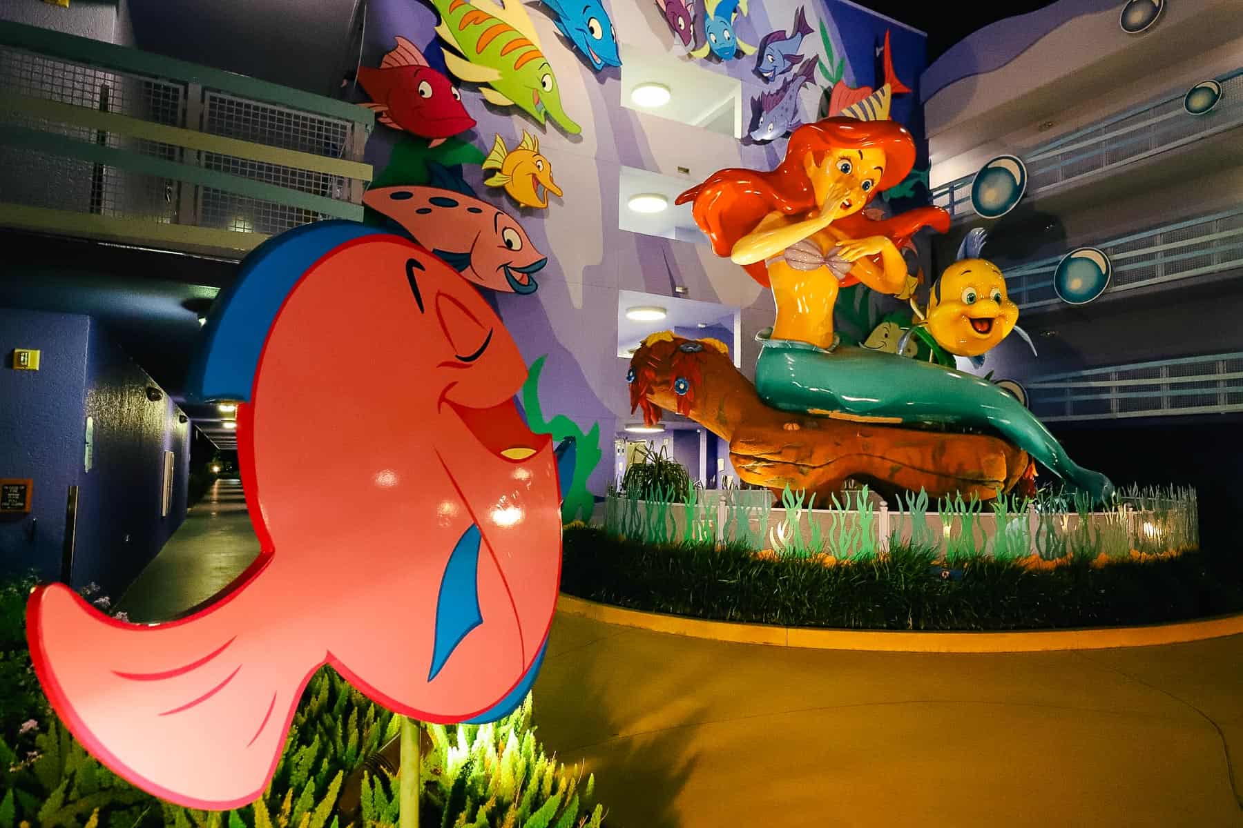 Ariel surrounded by Flounder and other fish at Disney's Art of Animation 