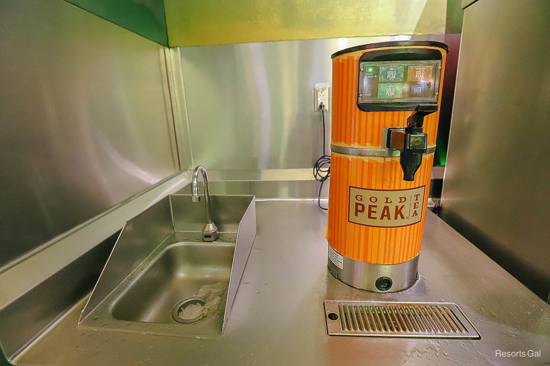 Gold Peak Tea machine at Art of Animation with a sink nearby for rinsing refillable mugs 