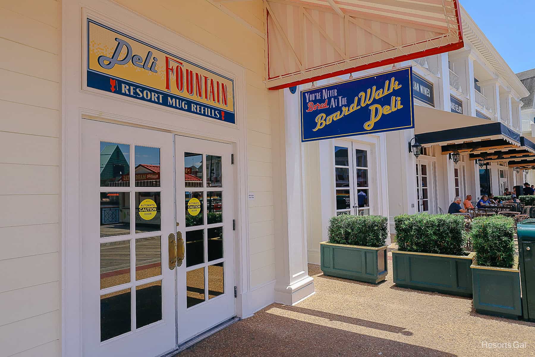 shows the entrance to Boardwalk Deli with a sign that reads "Deli Fountain Resort Mug Refills"