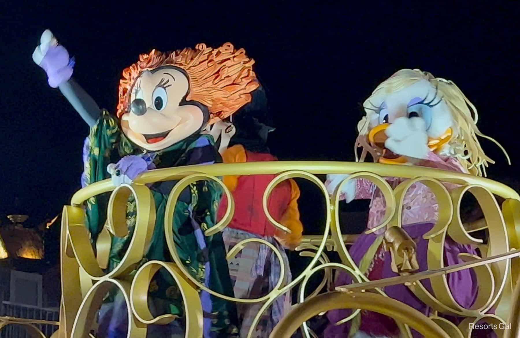 Minnie Mouse, Daisy Duck and Clarabelle Cow as characters dressed as the Sanderson Sisters in the Boo To You Parade 