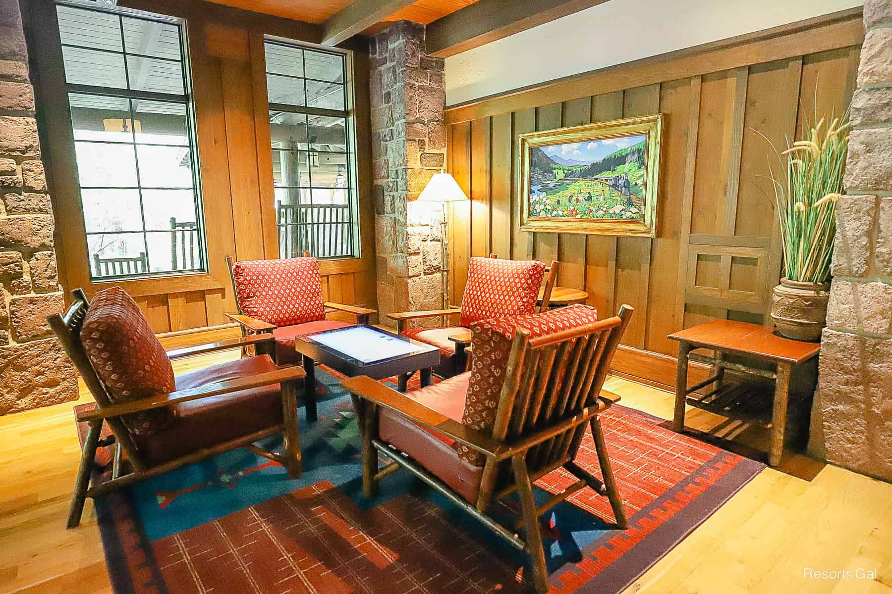 An electronic game table with chairs surrounding it in the train room for guests to enjoy. 