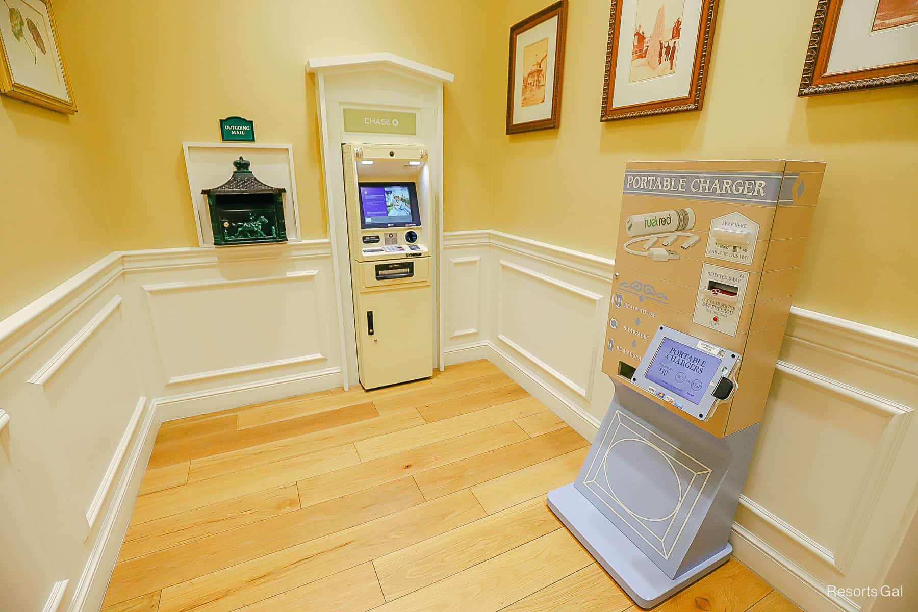 a nook in the lobby with an ATM, portable charger, and a mail area 