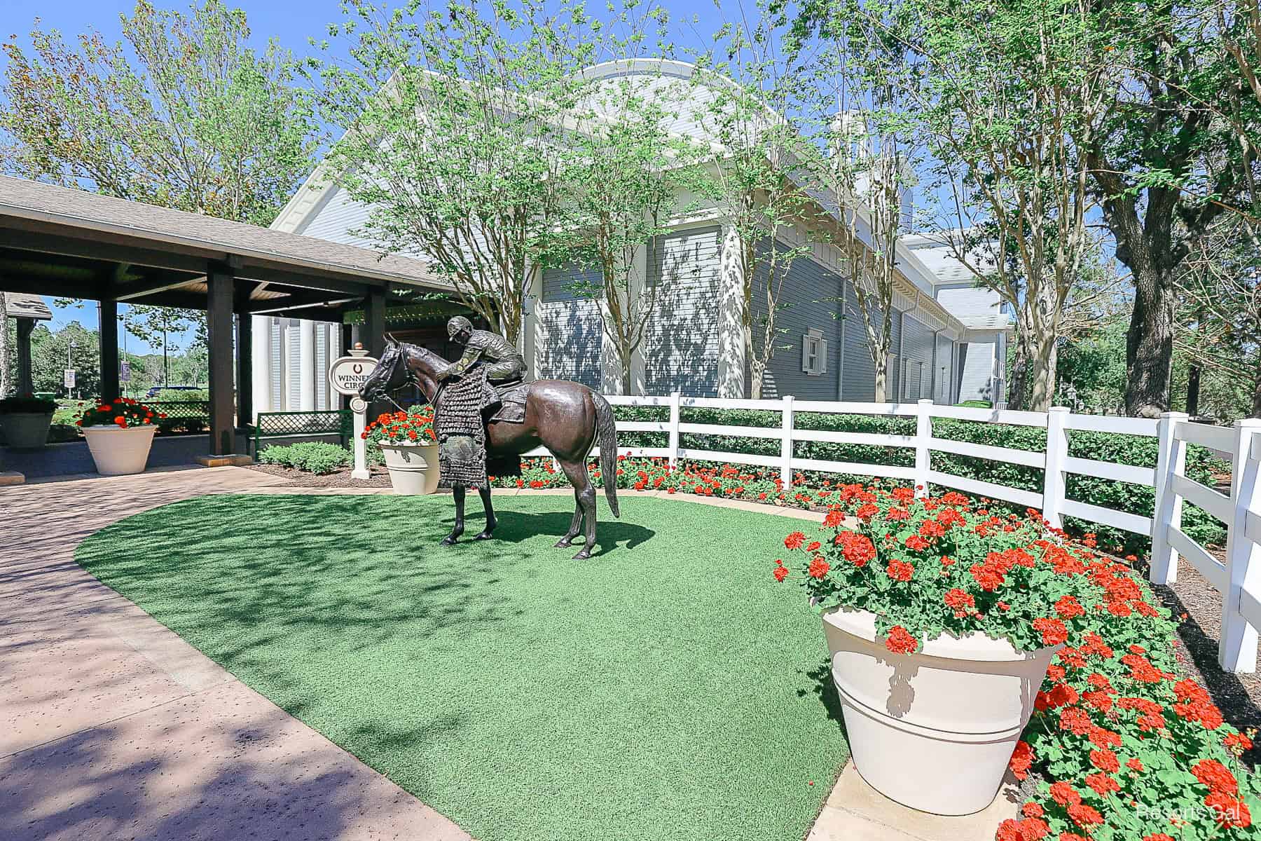 Winner's Circle display with green grass and red Begonias in potted plants