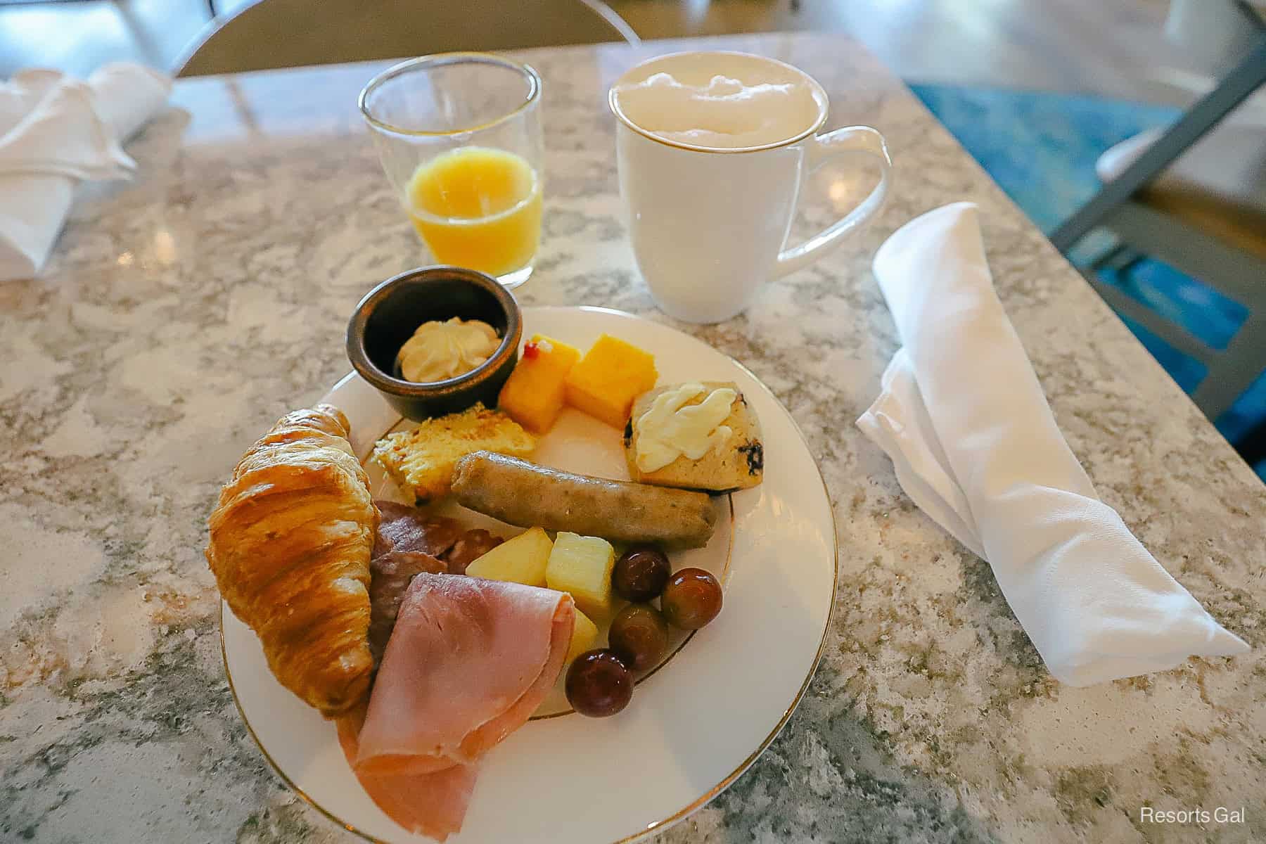 a prepared plate with breakfast items and a foamy coffee and glass of juice at club level 