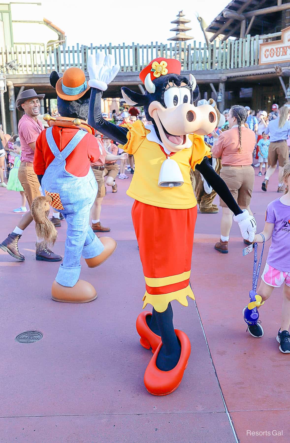 Clarabelle Cow waves with Horace Horsecollar behind her at Disney World. 