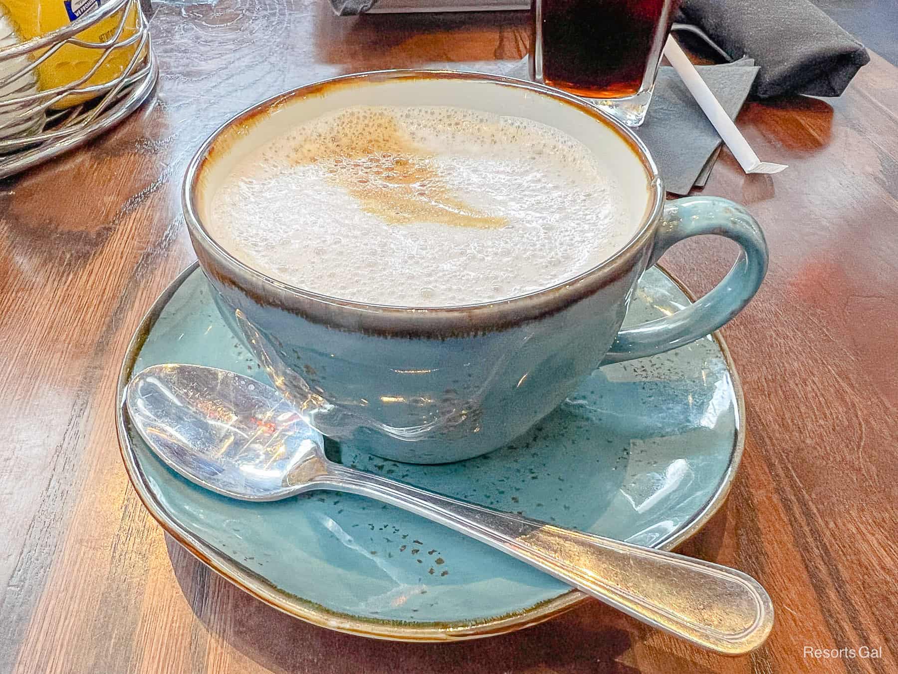 a cappuccino in an overside blue mug with saucer 