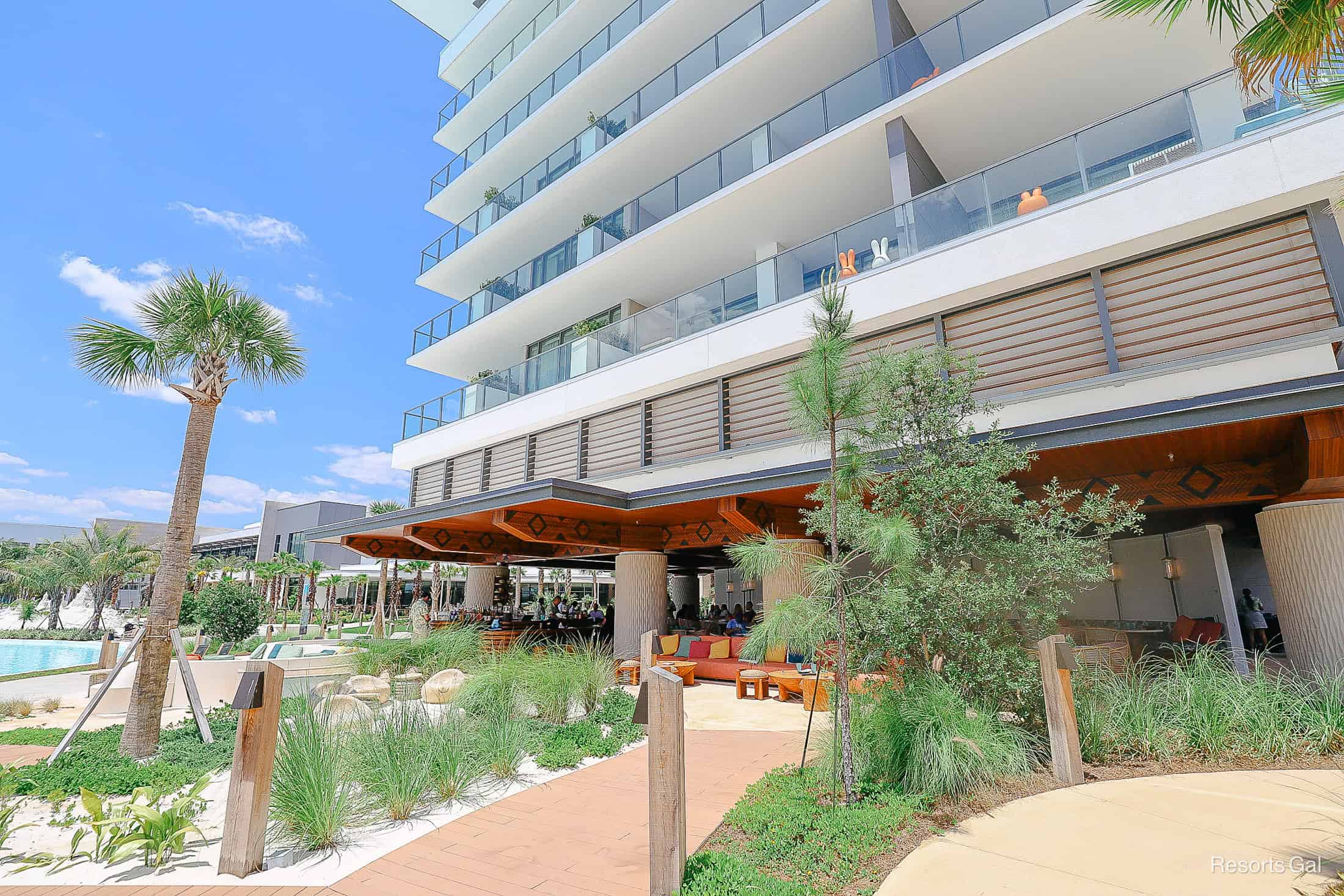 a view of the pool lounge under a covered area at the base of the Conrad Hotel 