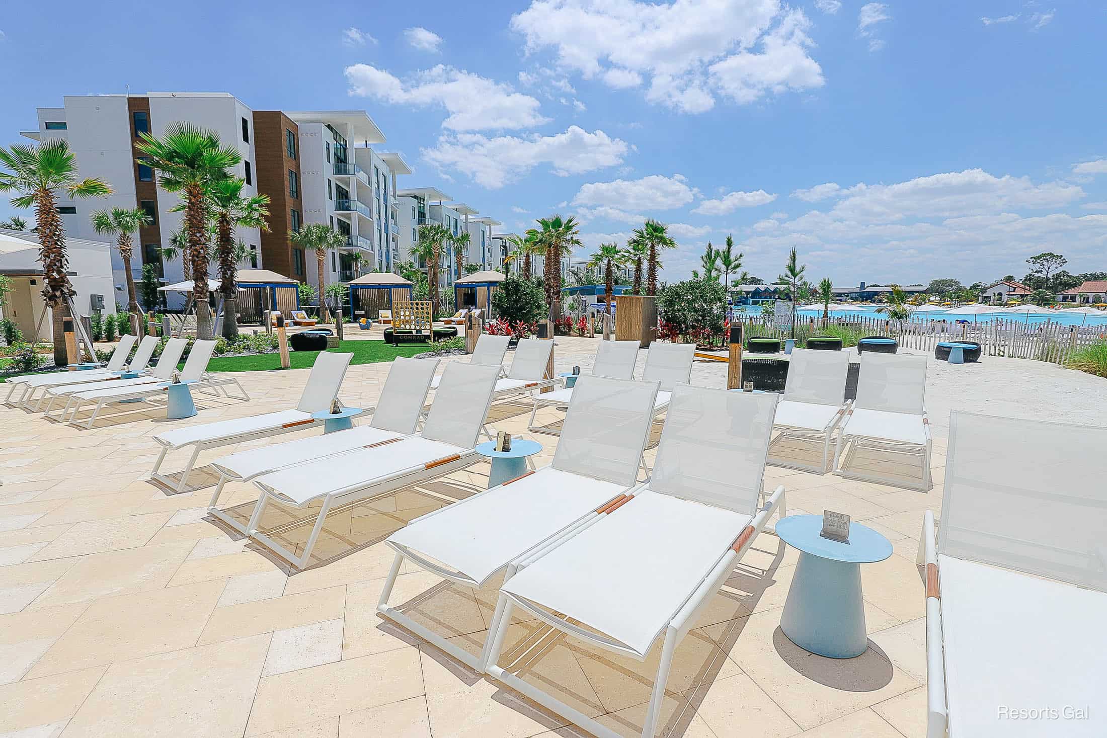 lounge chairs sitting in neat rows with small blue tables between them at the Conrad Orlando Hotel 