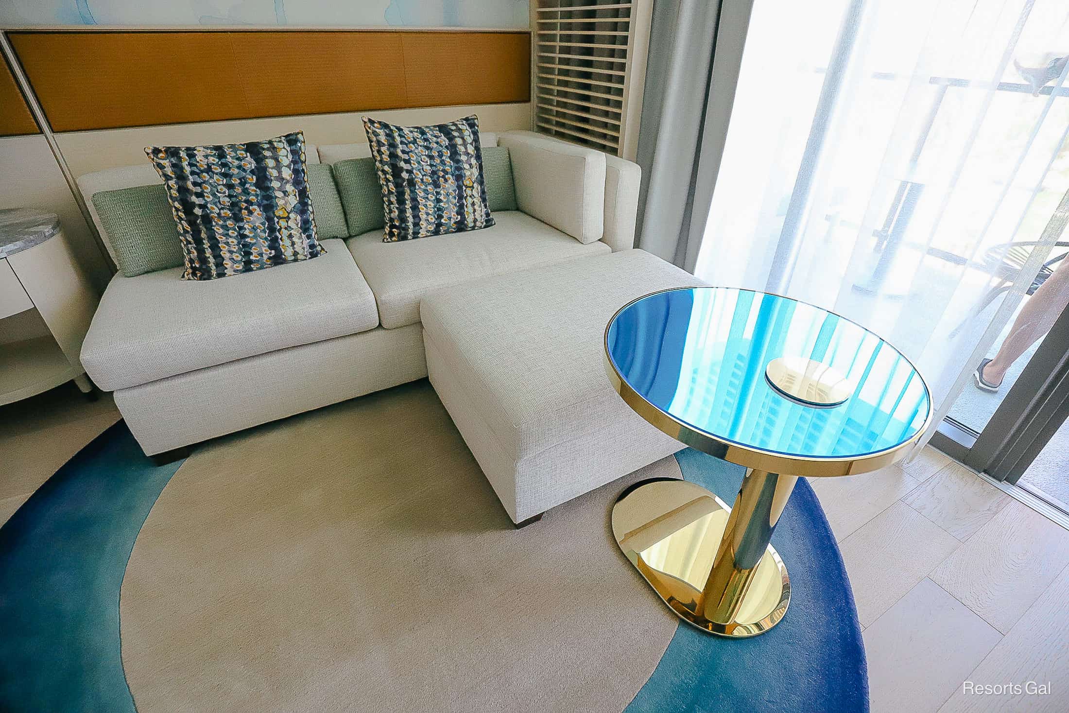 a small sofa with an ottoman and a rug in the king suite room at the Conrad Orlando. 