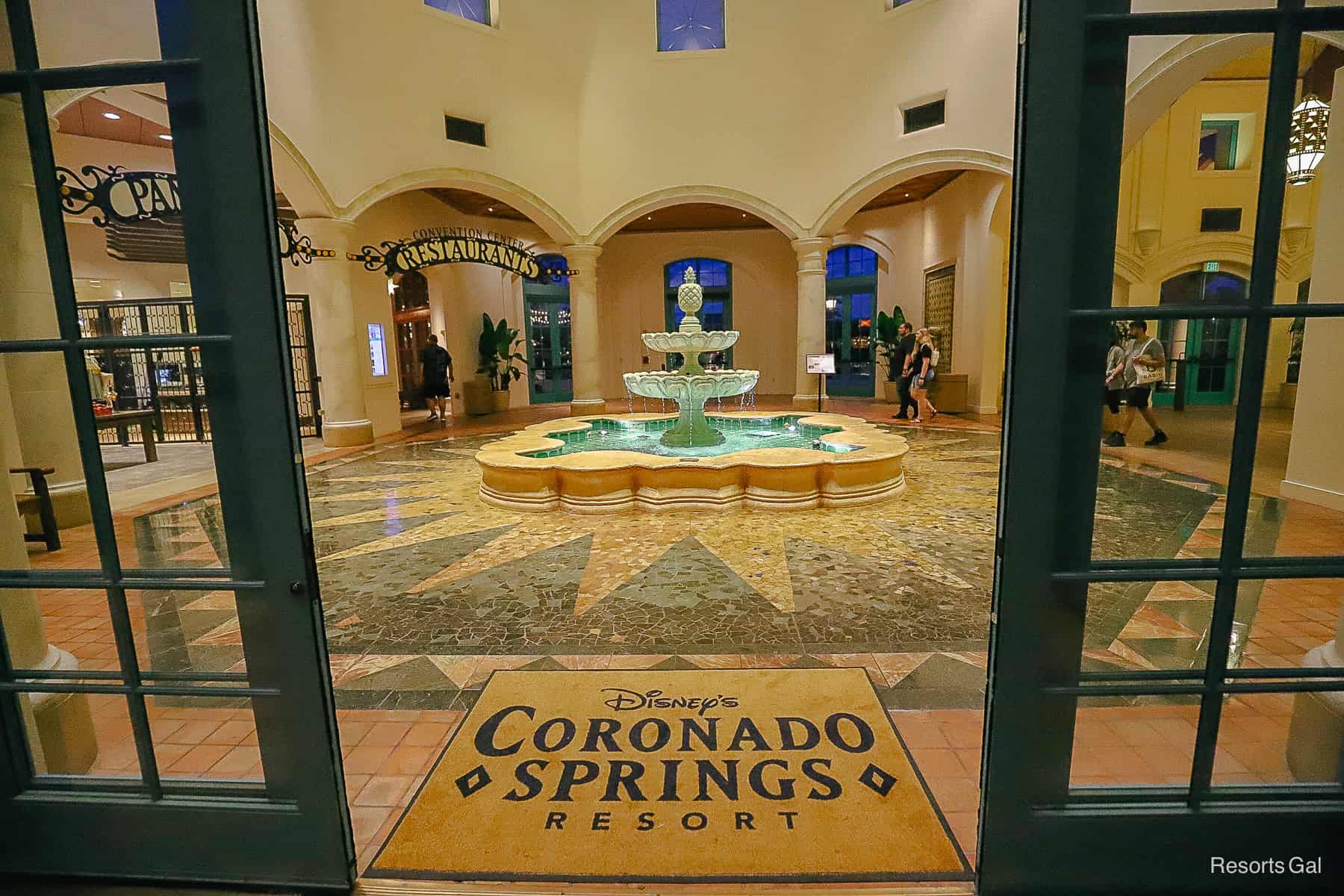 the sliding doors partially opened to reveal a door mat that reads Disney's Coronado Springs 