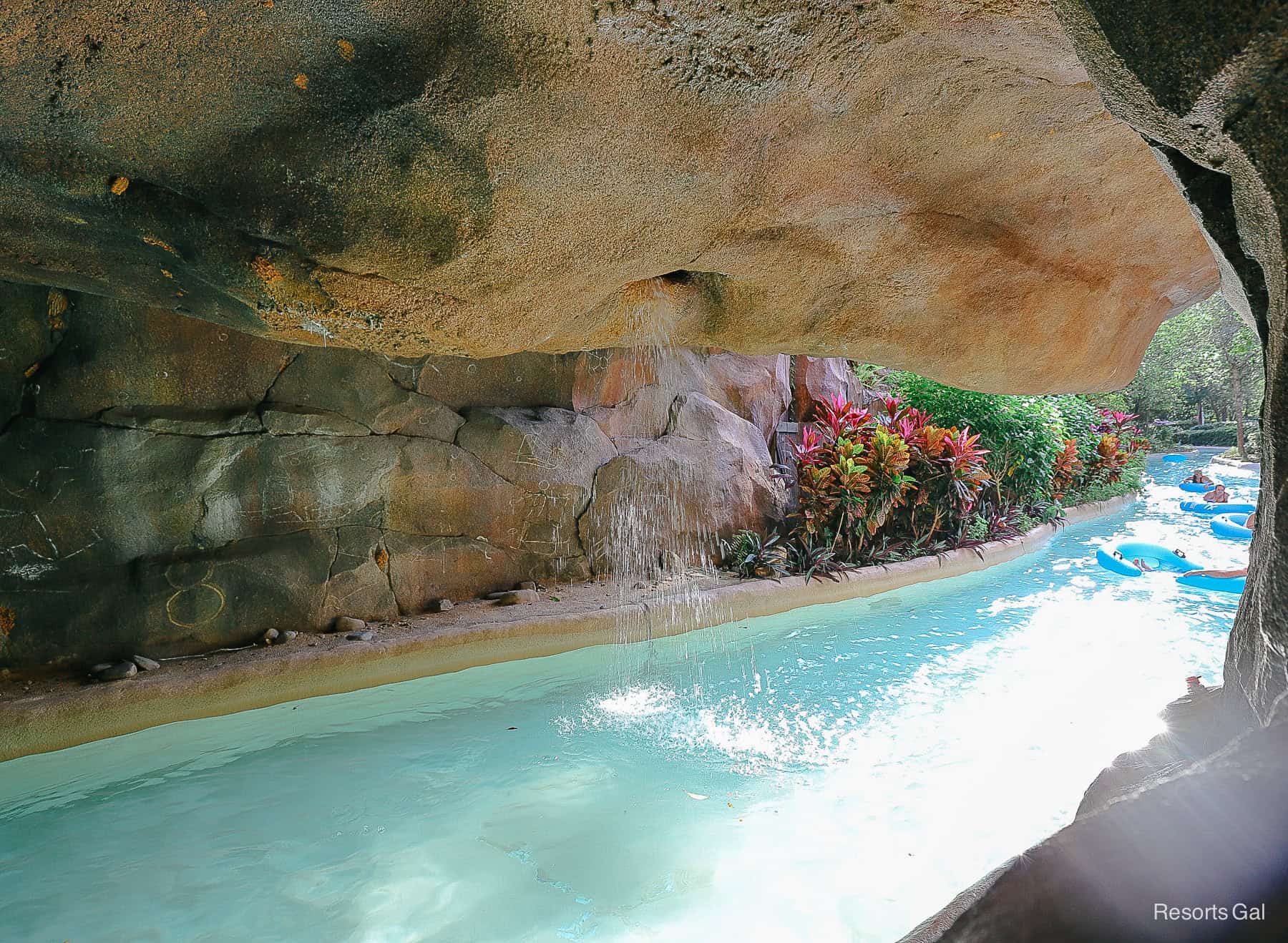 The exit of the cave in the lazy river with lush landscaping. 