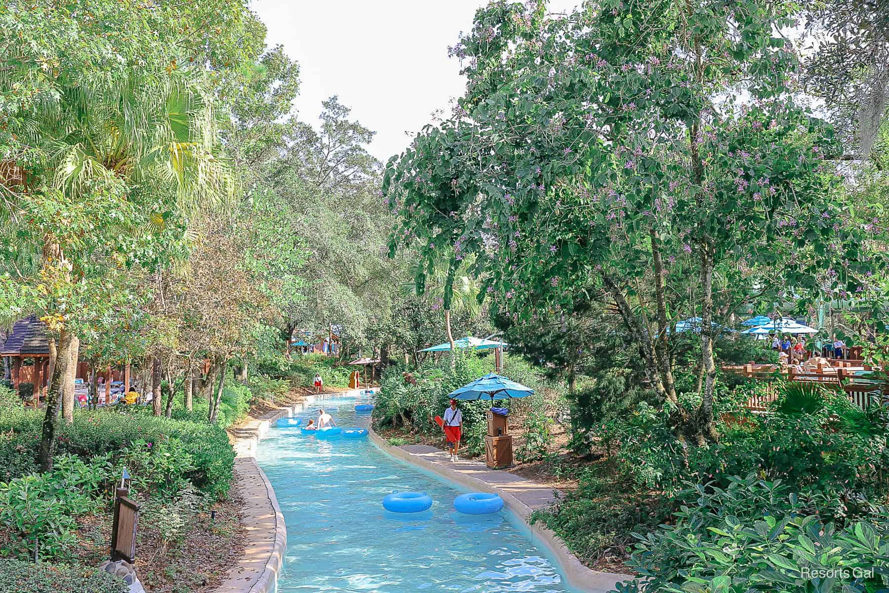 A lifeguard watches as guests float by in the lazy river. 