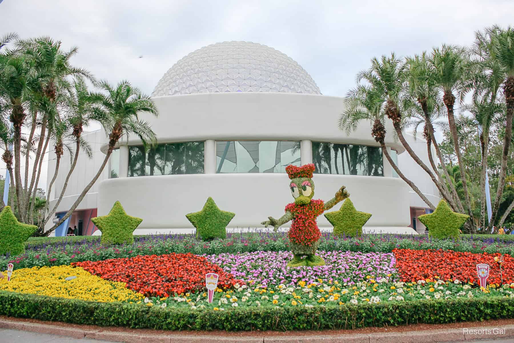 Daisy Duck topiary in a vibrant flower bed in 2019 behind Spaceship Earth 