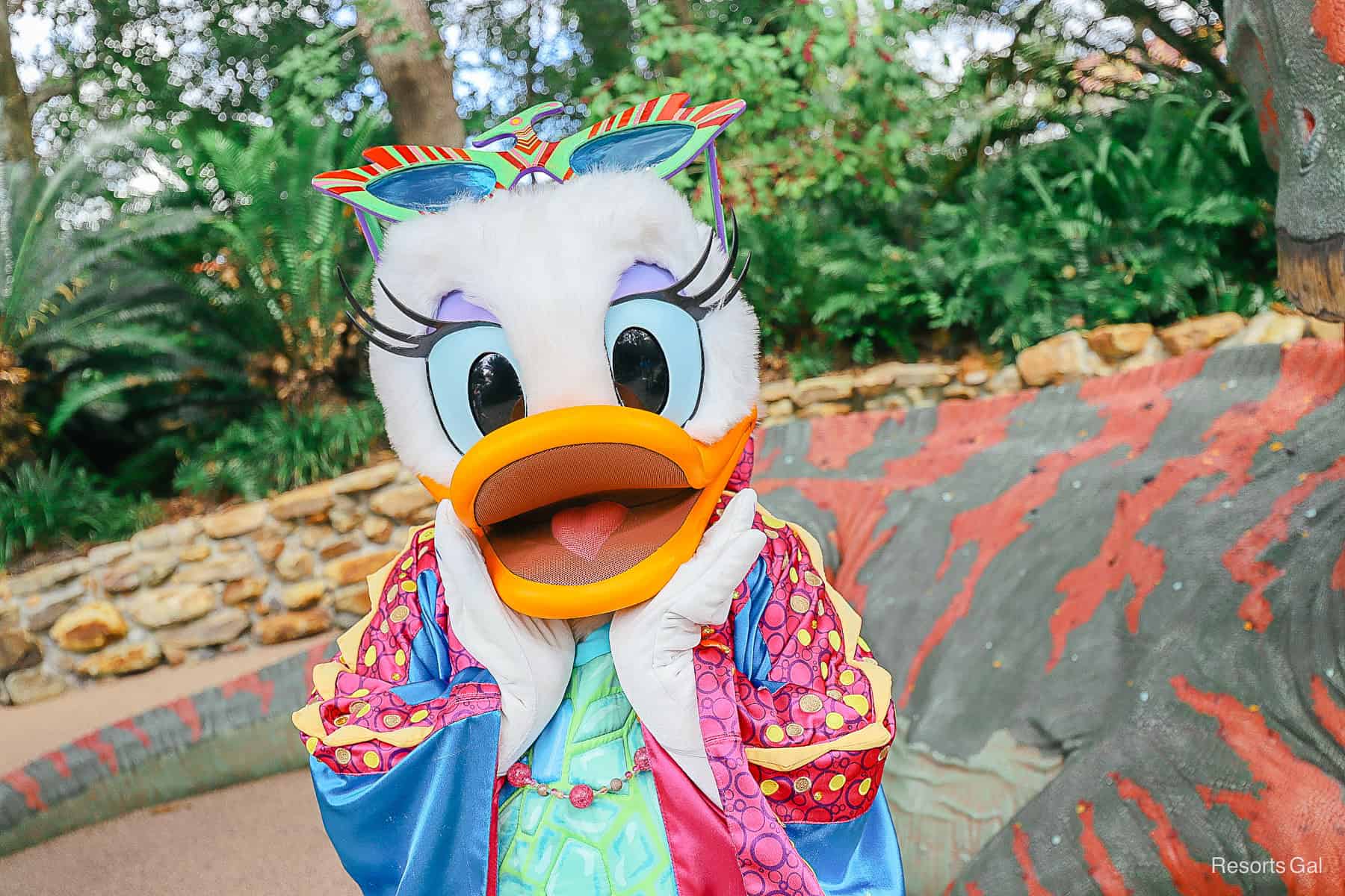 Daisy Duck with hands on cheeks as she poses for a picture. 