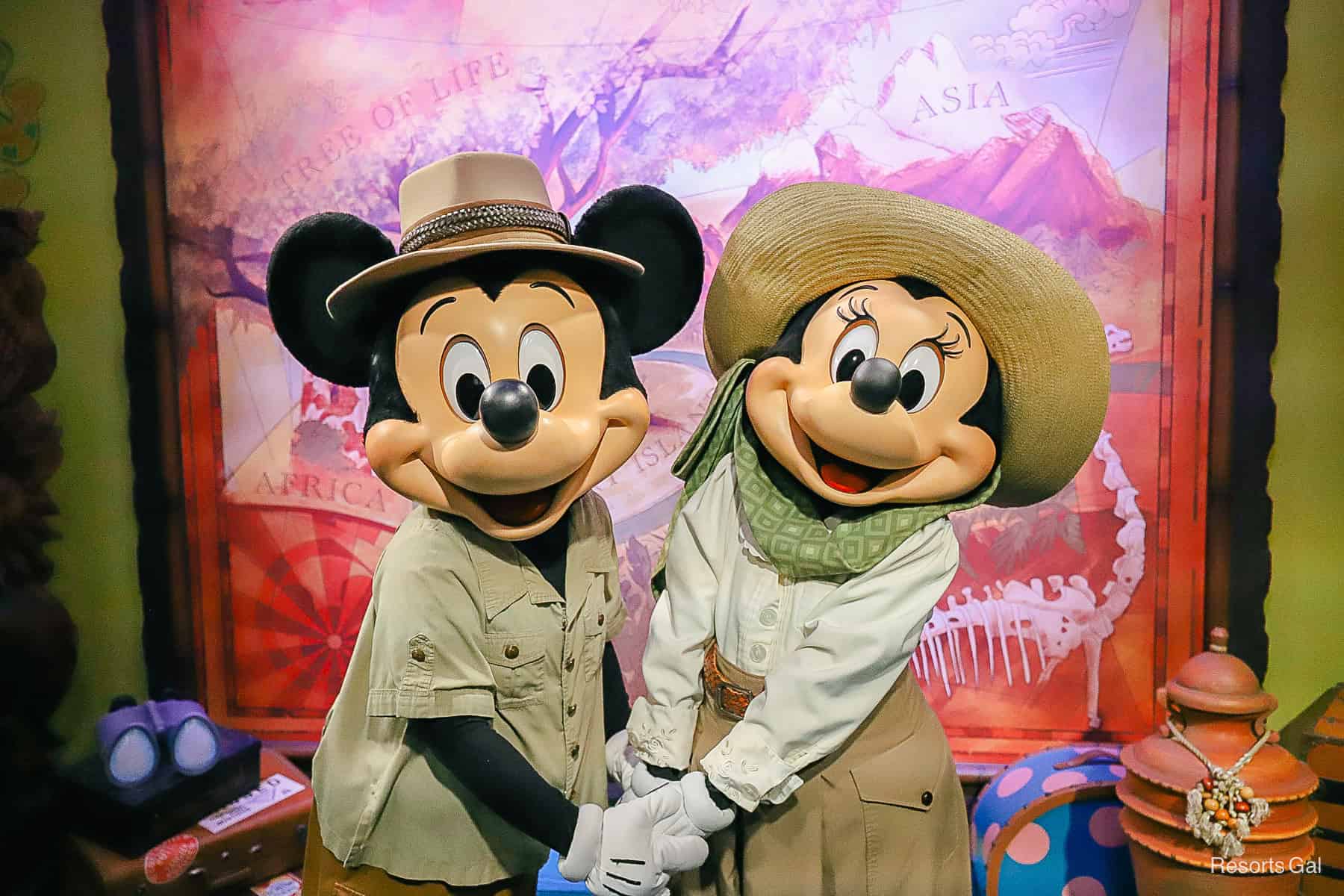 Mickey and Minnie Mouse pose together holding hands at Adventurer's Outpost. 