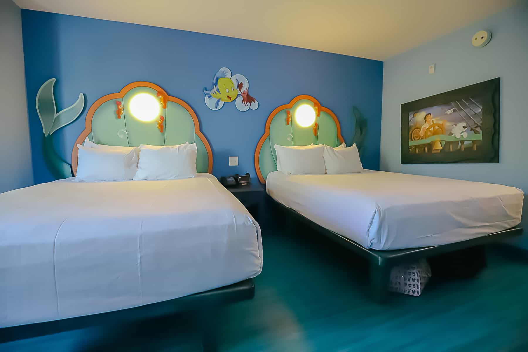 Shows two queen-size beds in the room. 