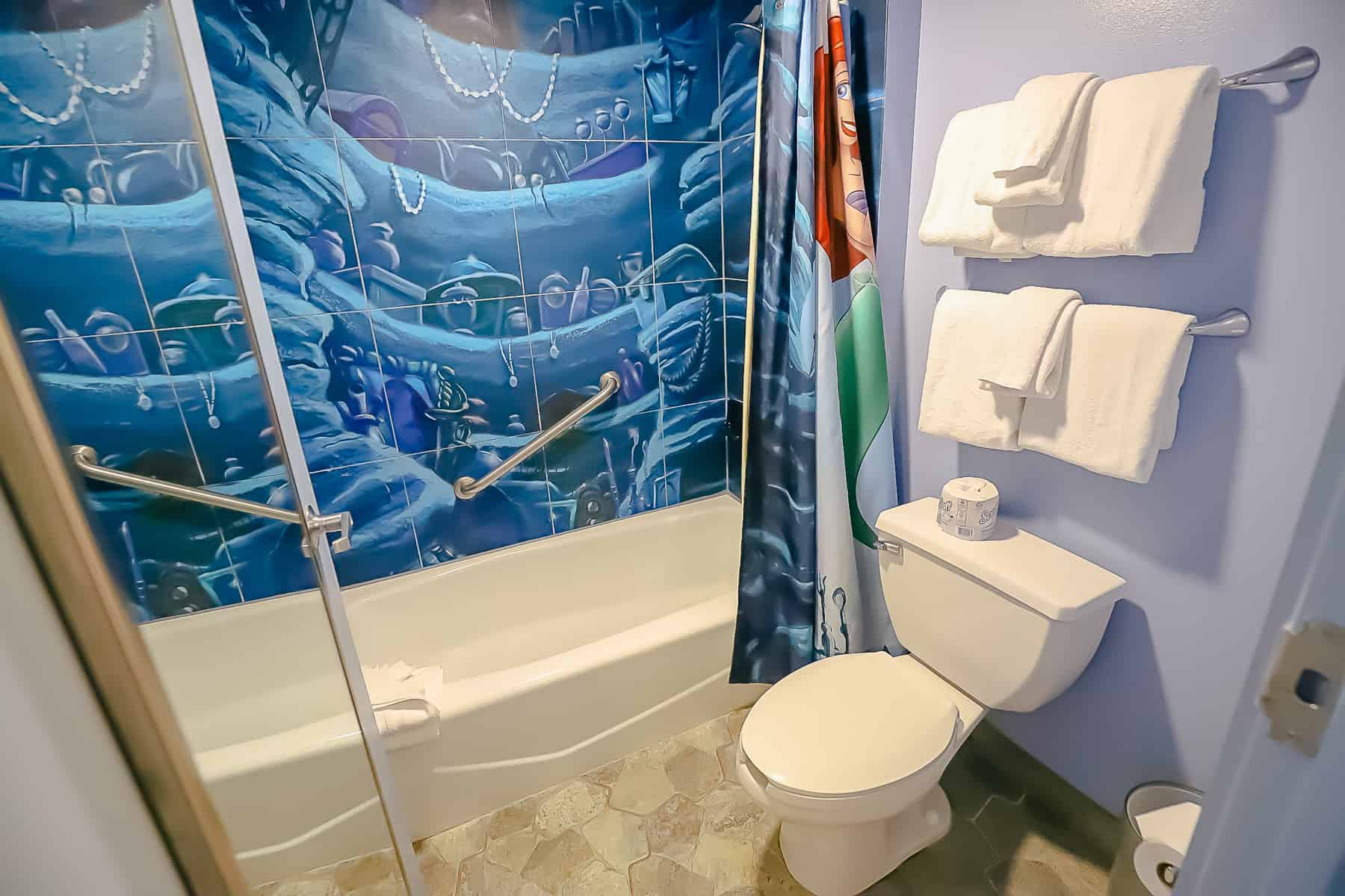 tub with shower curtain in water closet at Art of Animation Little Mermaid Room 