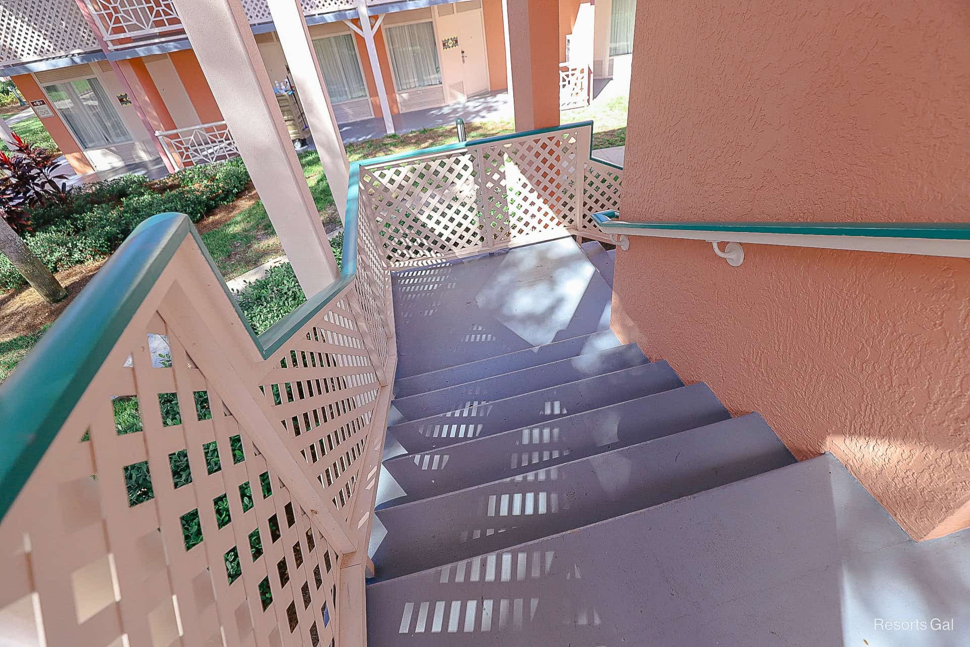 a pink staircase with grey stairs and blue hand rails 