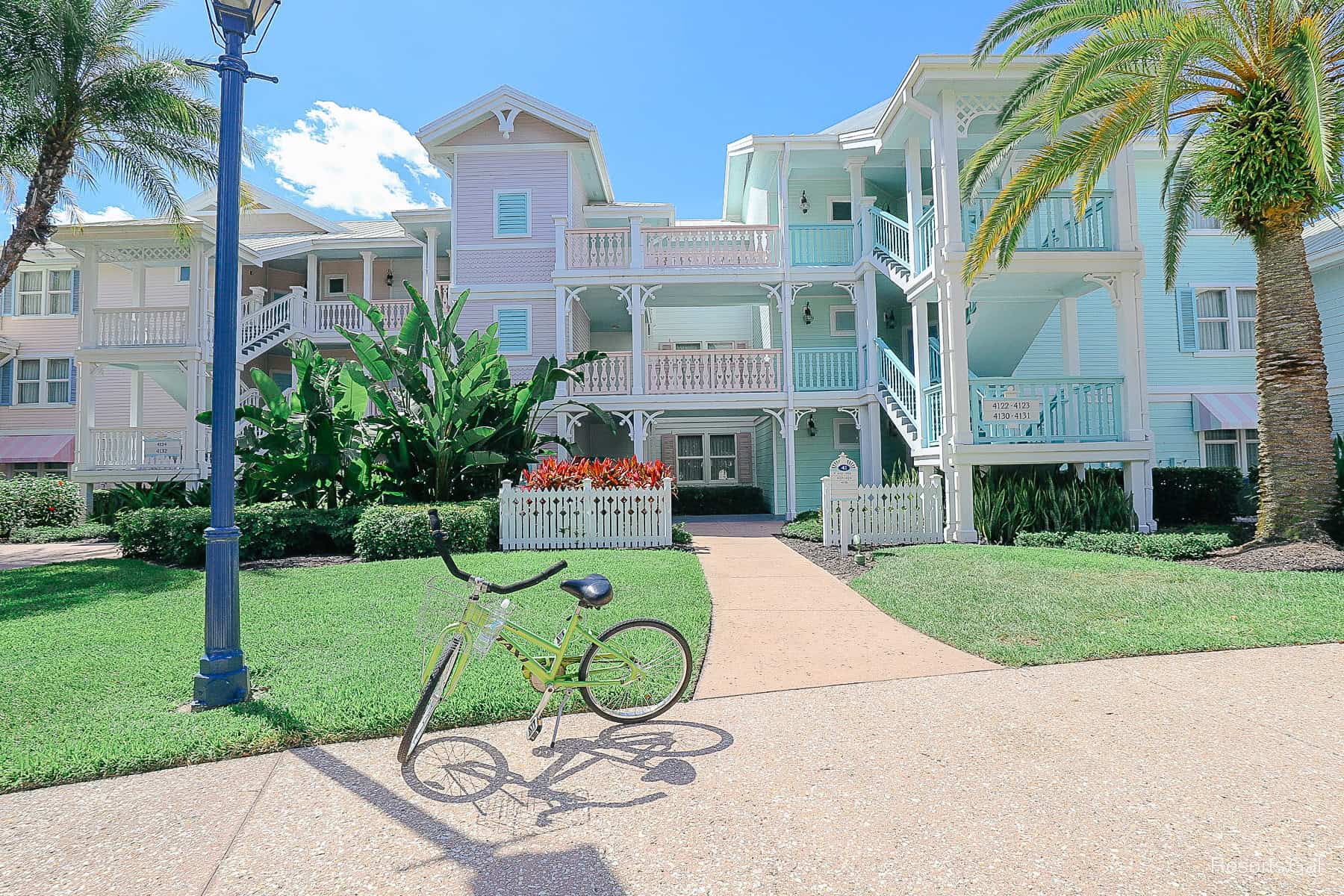 a rented bike from Old Key West sitting in front of the resort's buildings 