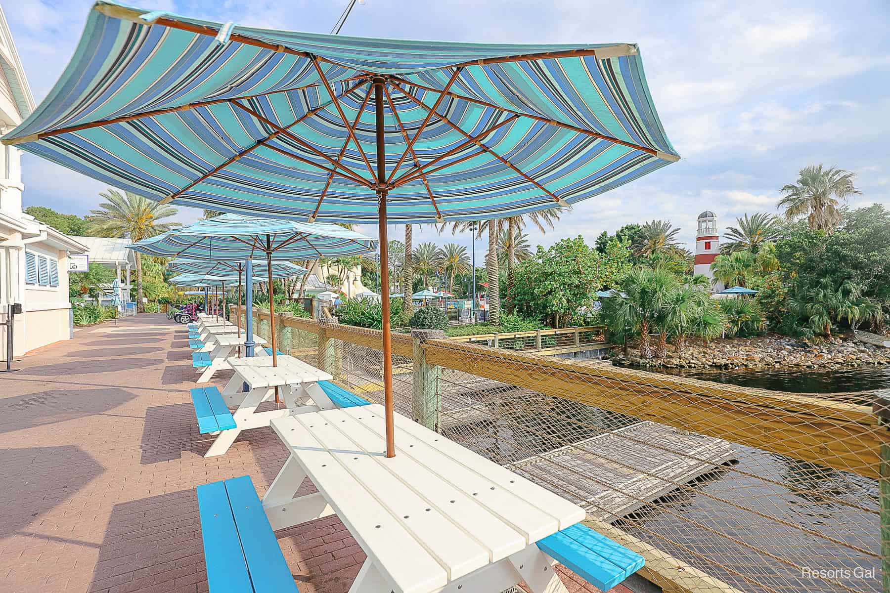 a row of picnic tables with striped umbrellas at Disney's Old Key West 