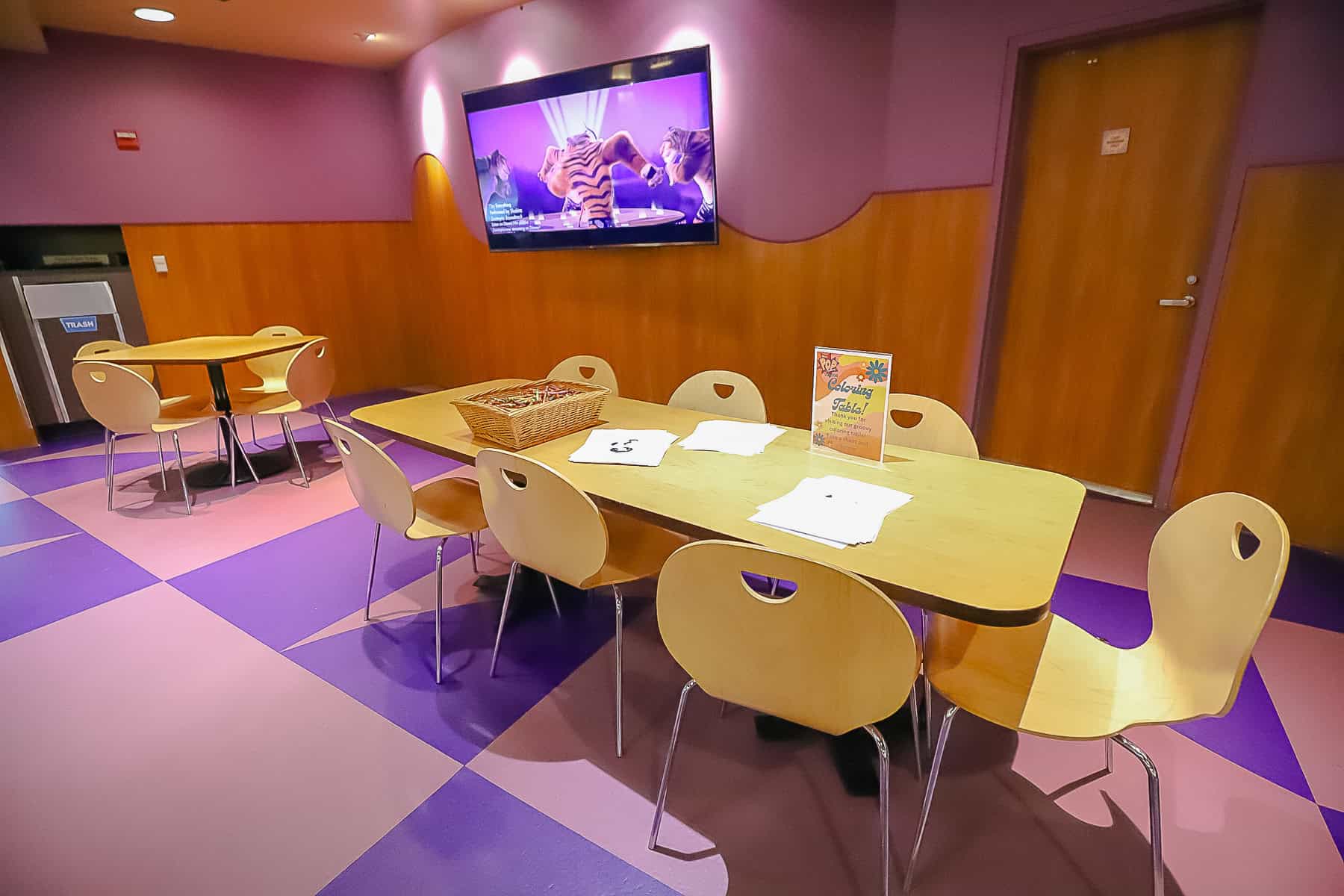 a table with crayons and colors for children in the dining room at Pop Century 