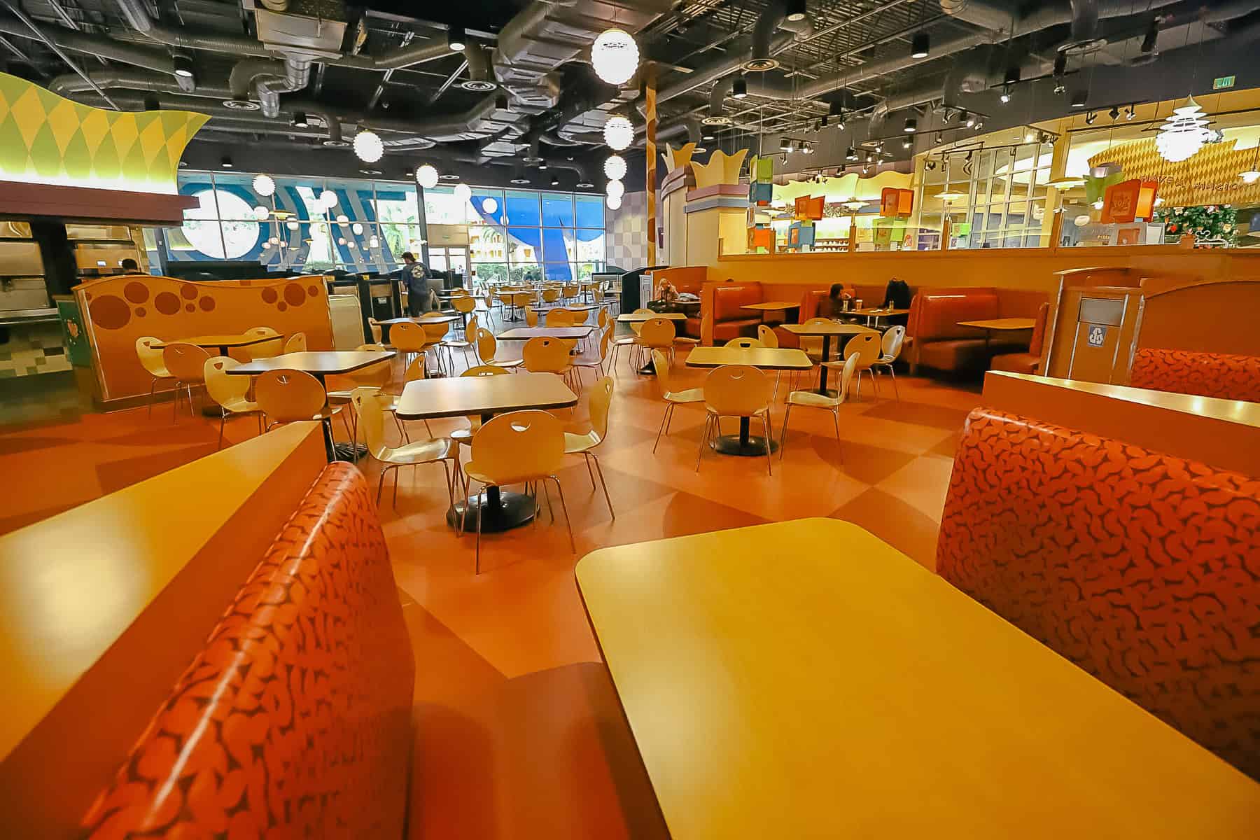 one of the dining area with booths and tables and chairs in the Pop Century's Food Court 