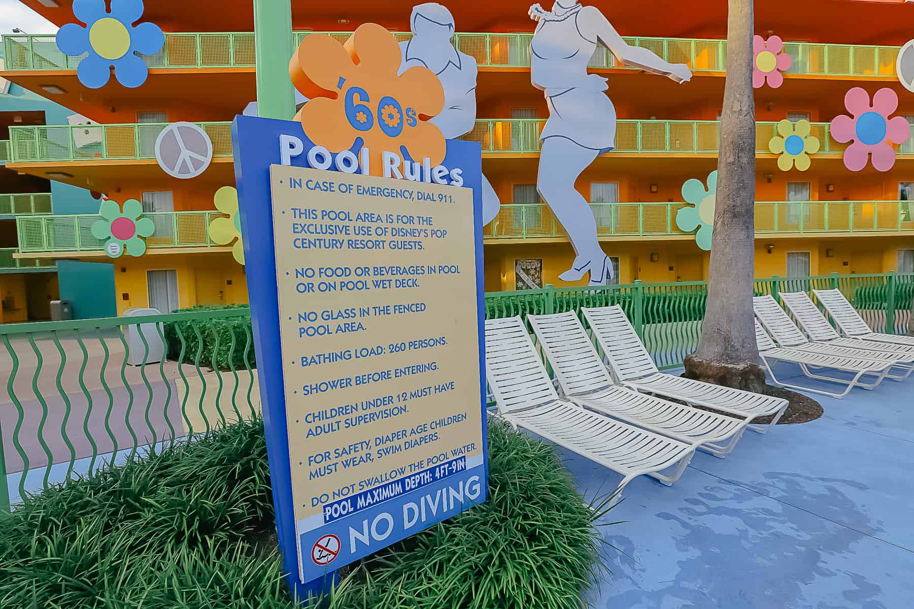 A sign that says the maximum pool depth is posted as 4 ft and 9 inches at the Pop Century Pools.