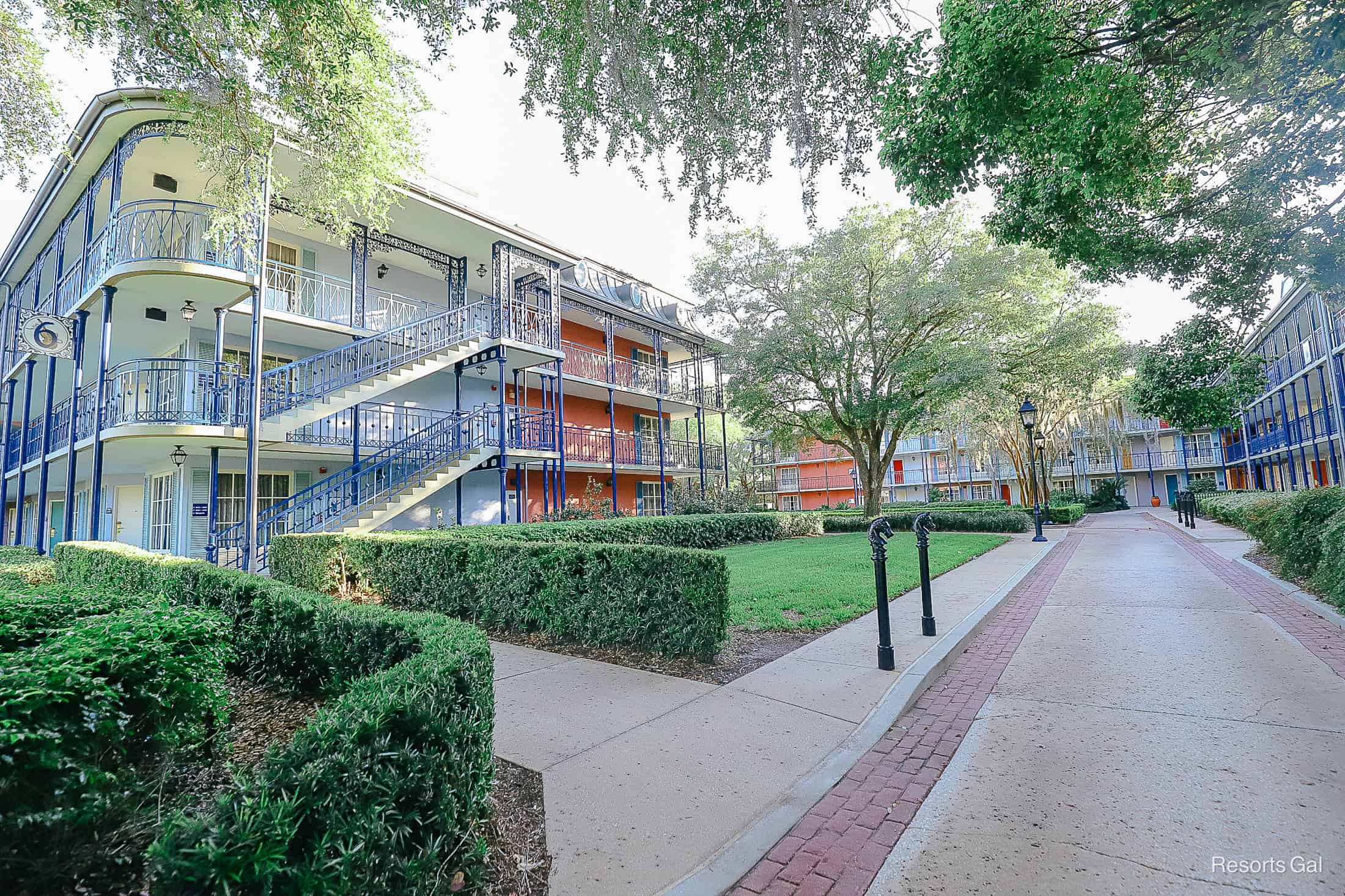 a shaded sidewalk through bright colored buildings at Disney's French Quarter Hotel 