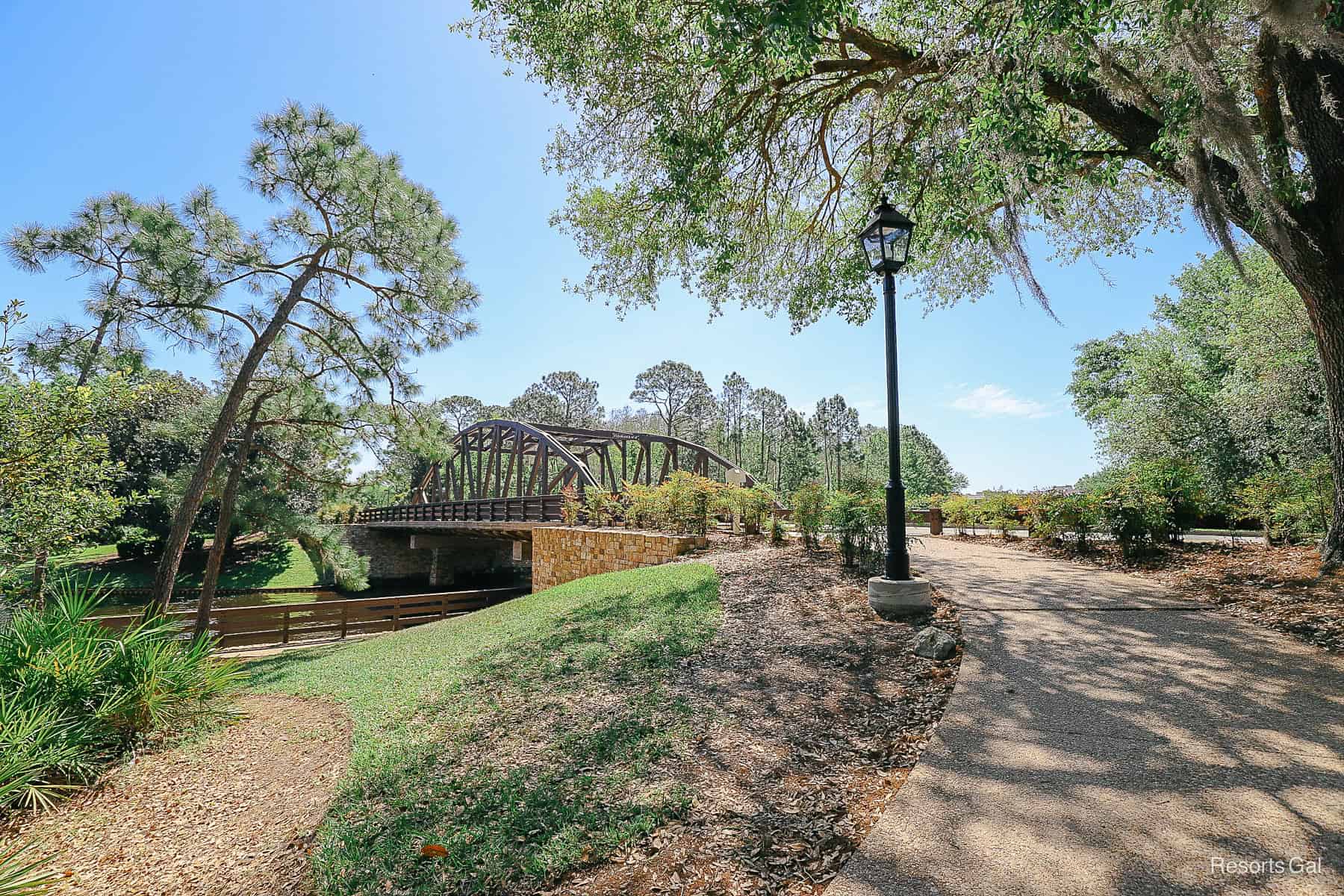 the walkway between the resorts with a bridge, tree, and lightpole 